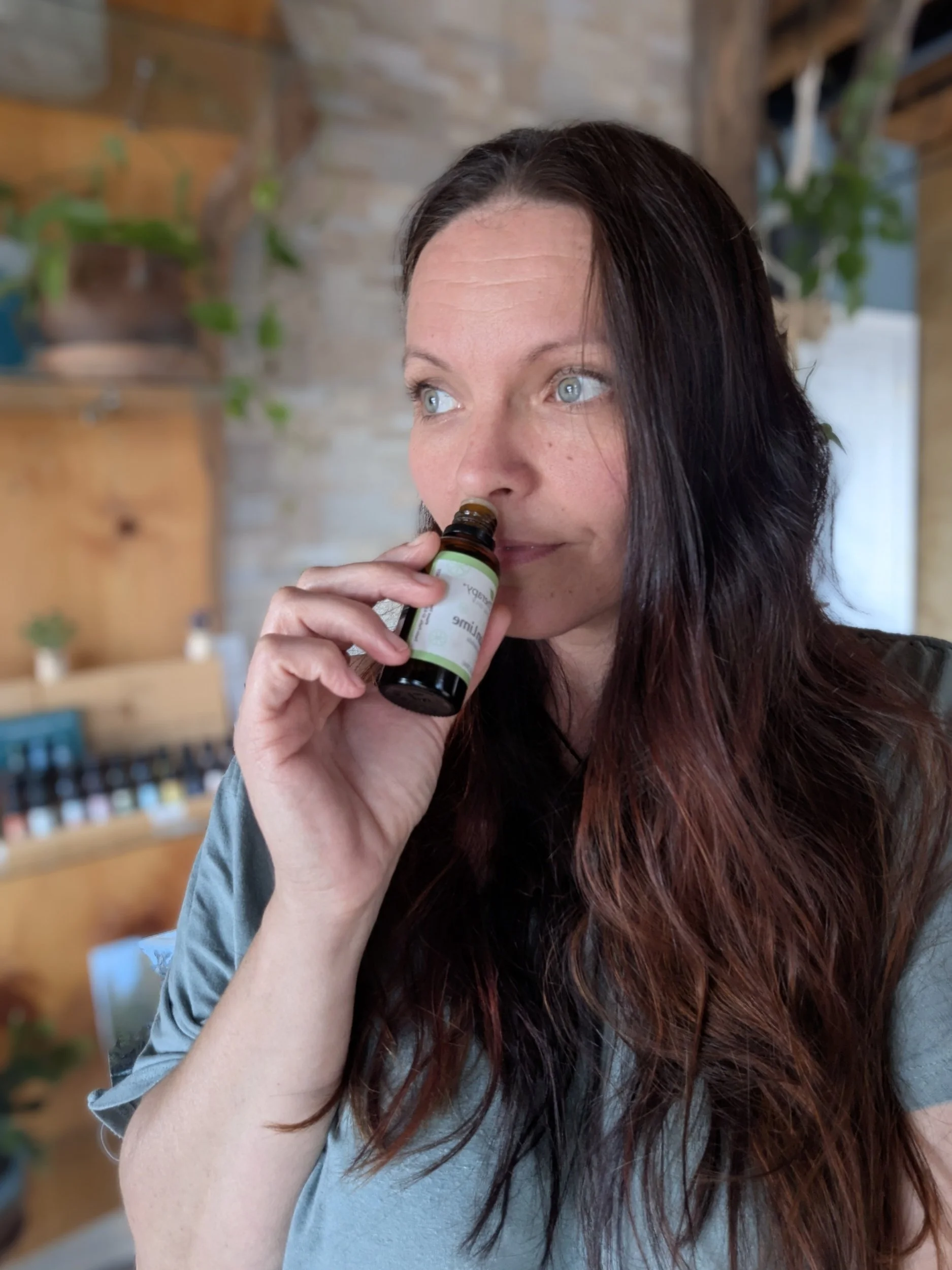 Woman smelling lime essential oil bottles.