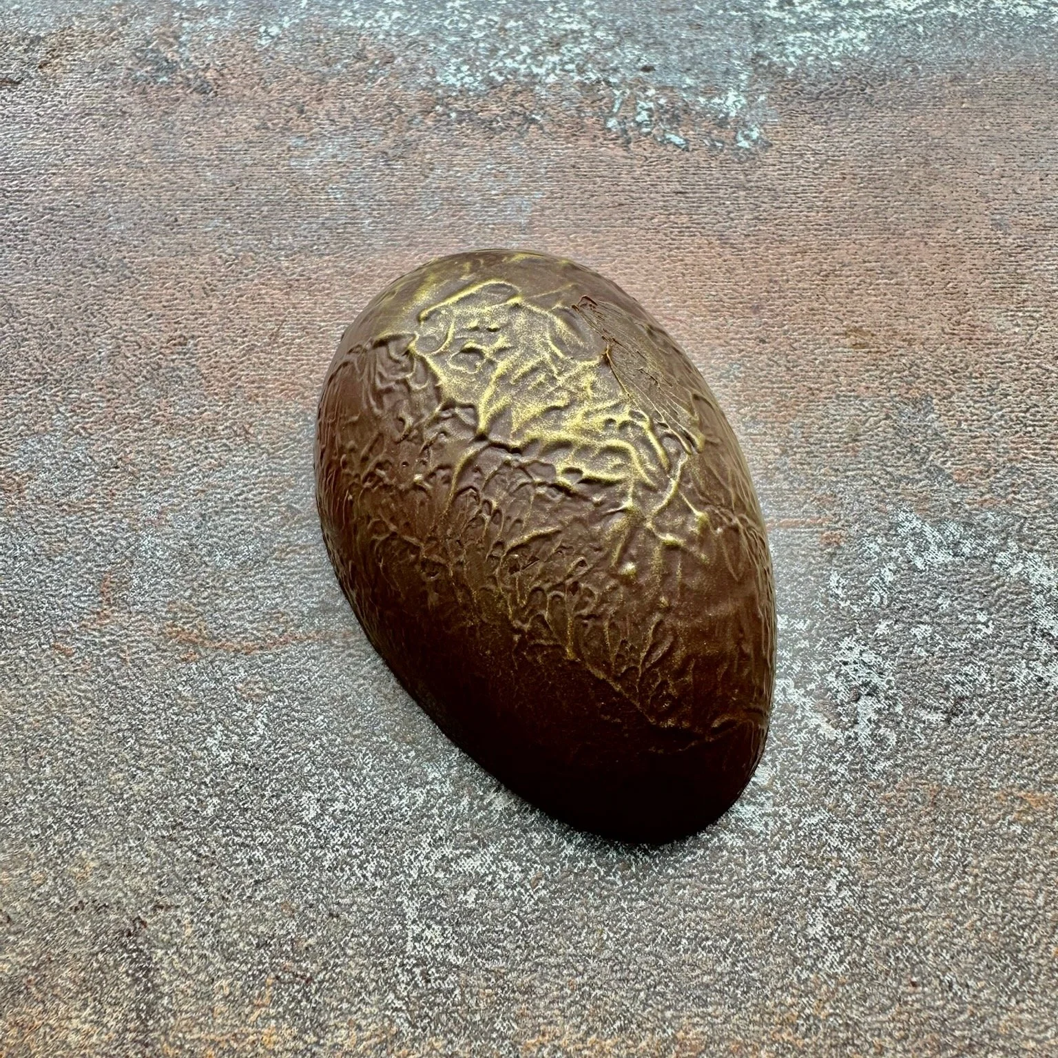 A golden textured half chocolate egg 
