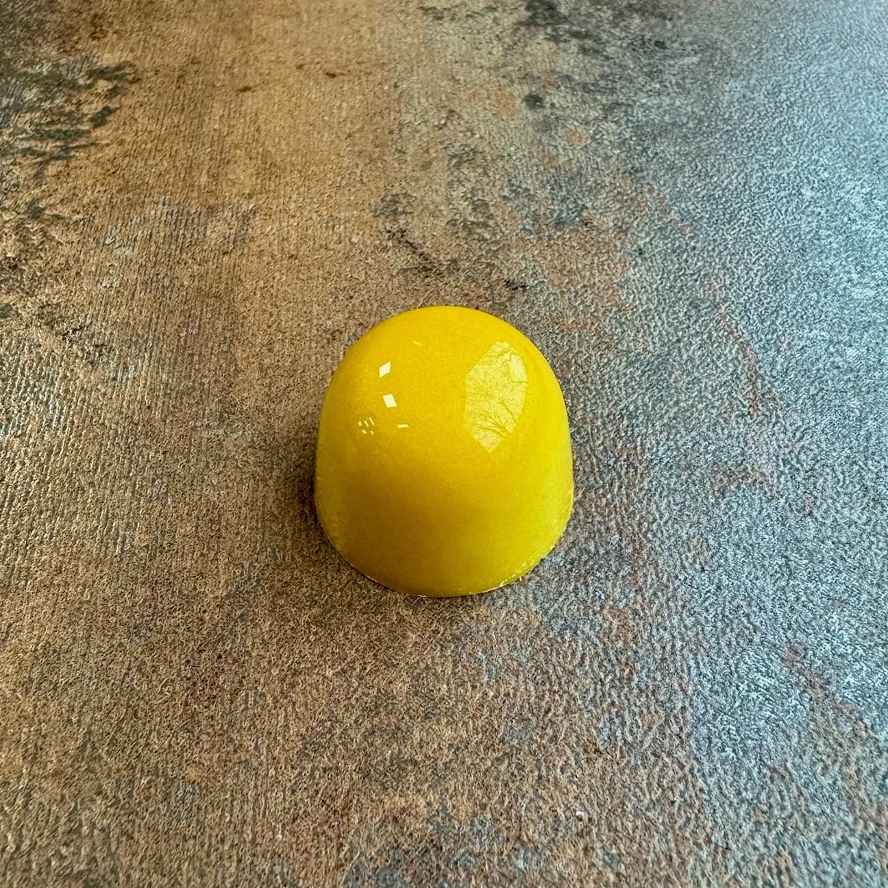 A yellow domed shiny bonbon