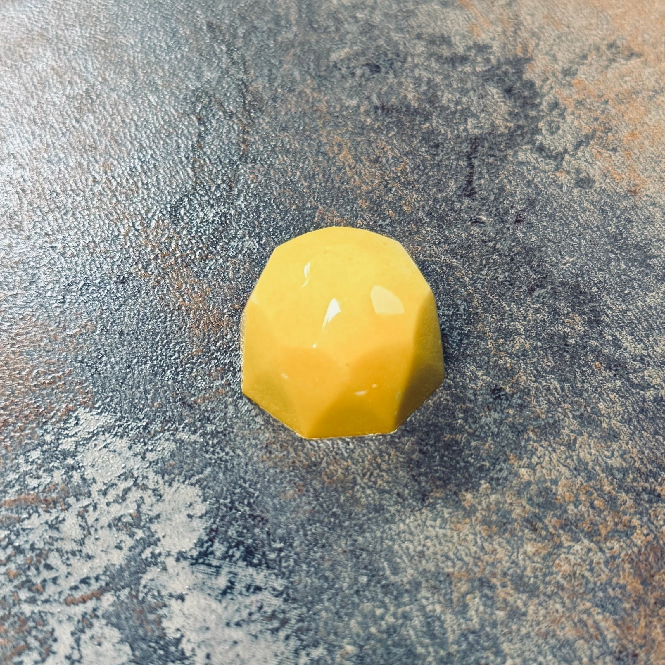 Yellowish multi-faceted bonbon