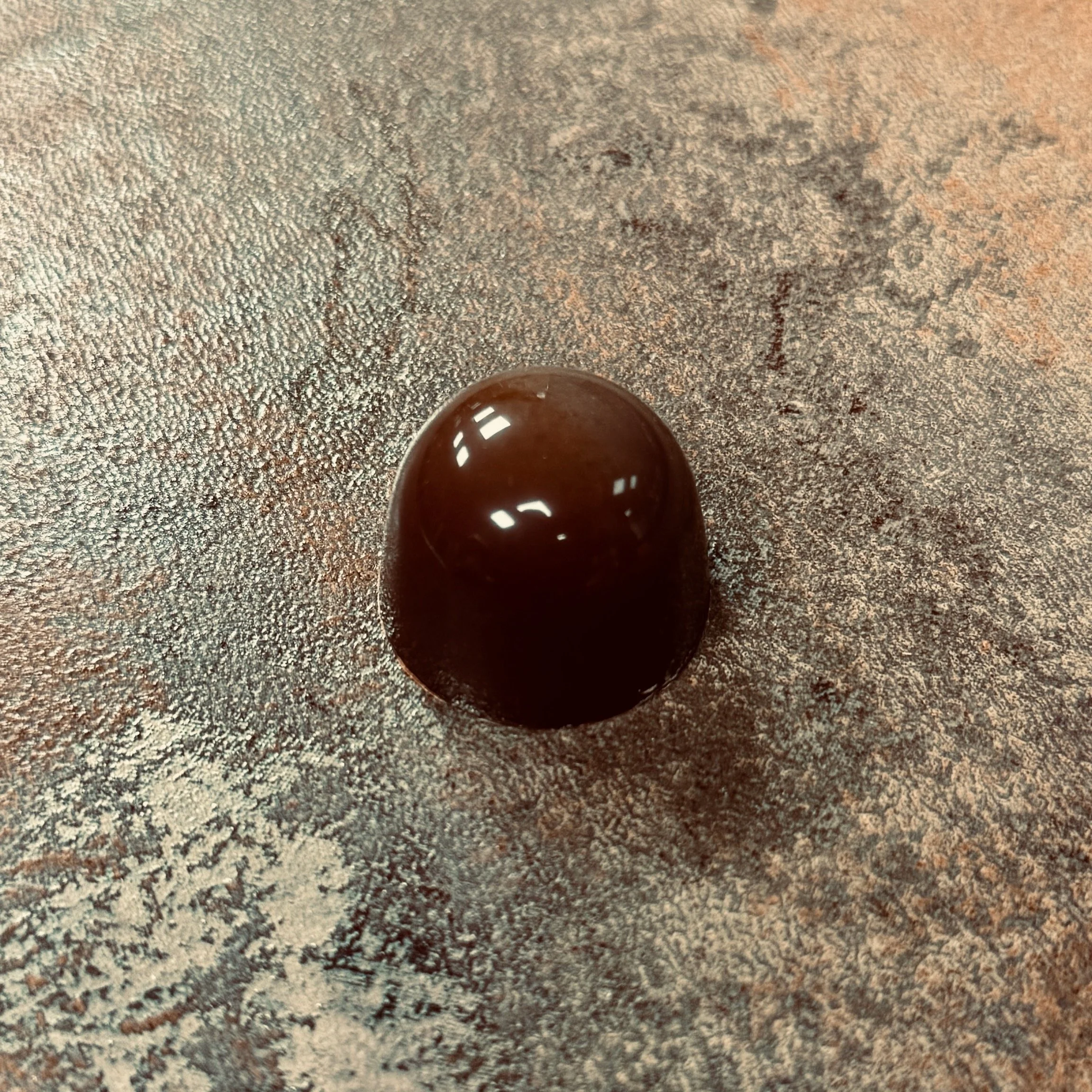 Red domed bonbon with a gold line