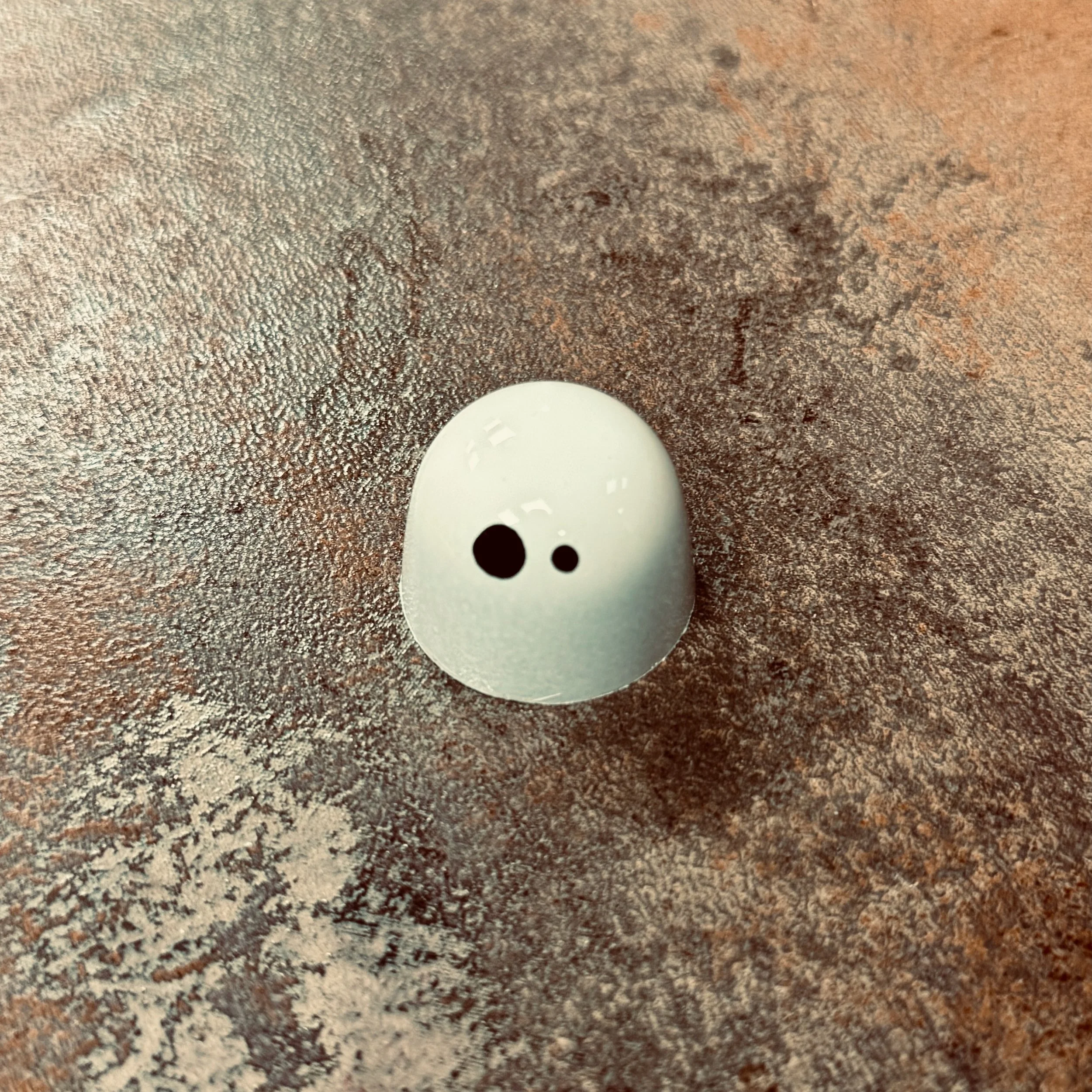 White domed bonbon with 2 black eyeballs