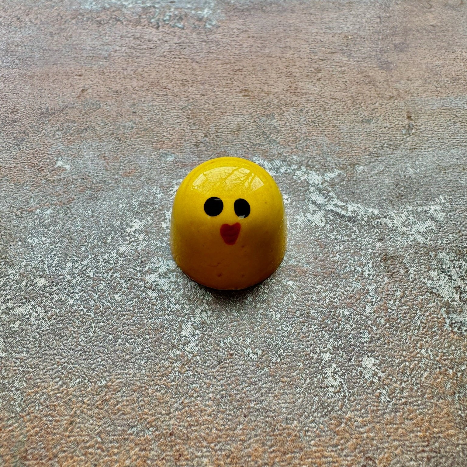 Yellow bonbon with eyes and lips painted