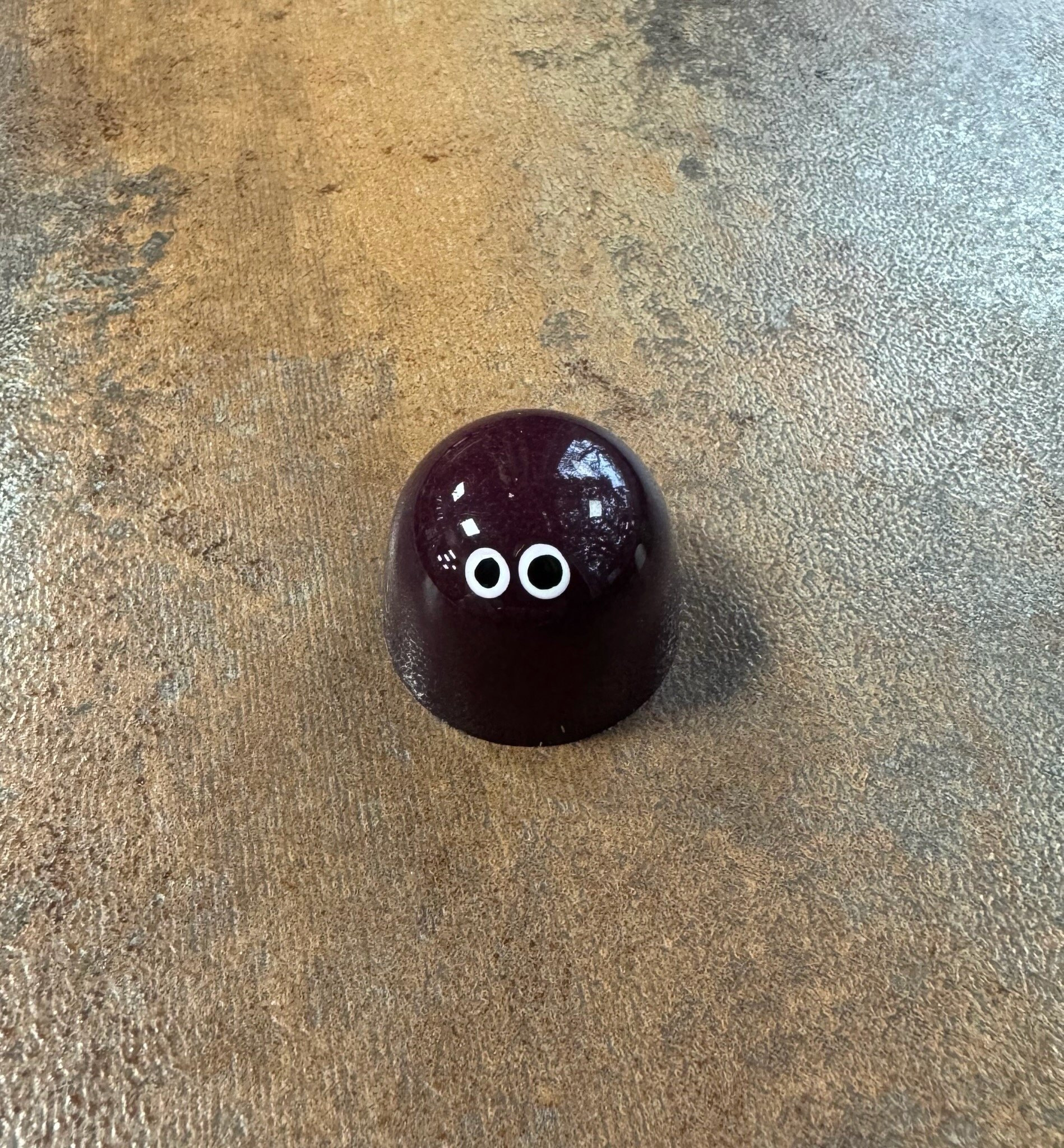 Black shiny bonbon with 2 white eyes