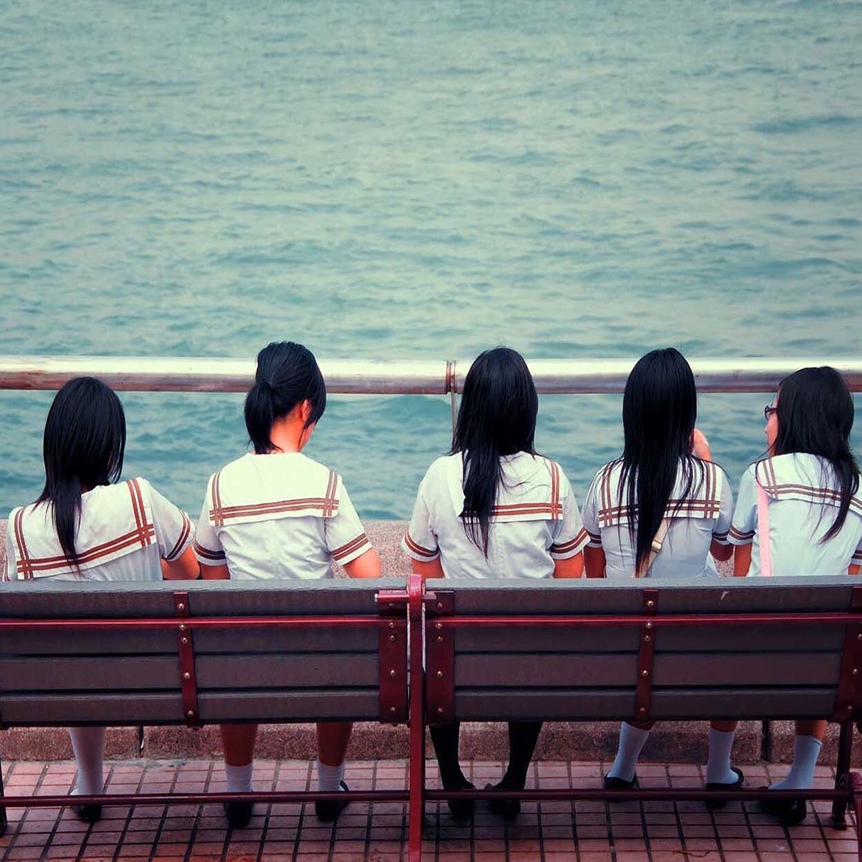 Five young schoolchildren meeting at lunch at Singapore harbour