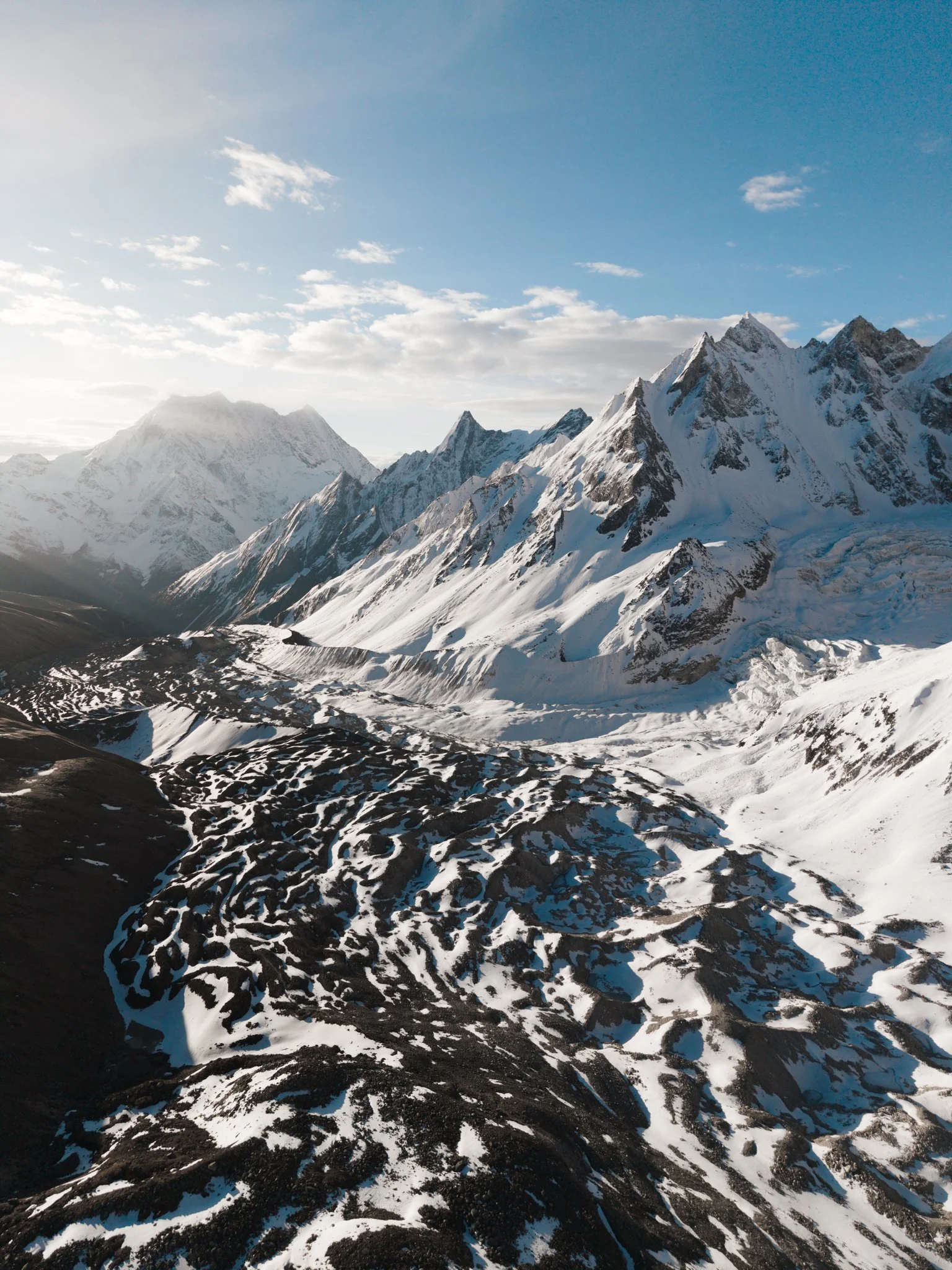 The descent side from Larkya La. The Annapurna range on the horizon — Day 9's view, peeking in early.