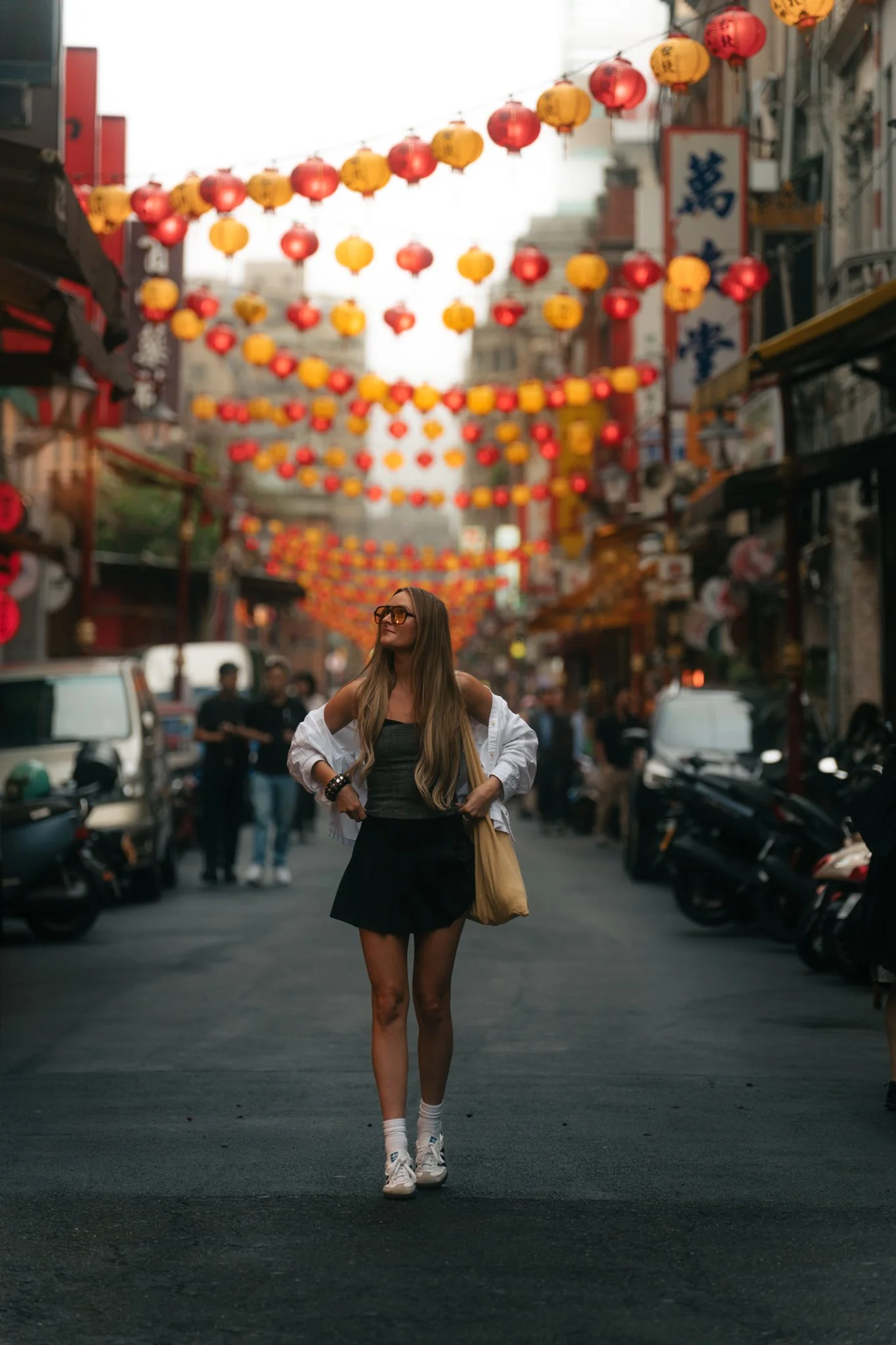 Karlie Place walking through Dadaocheng Historic District with colorful lanterns overhead, Taipei Taiwan