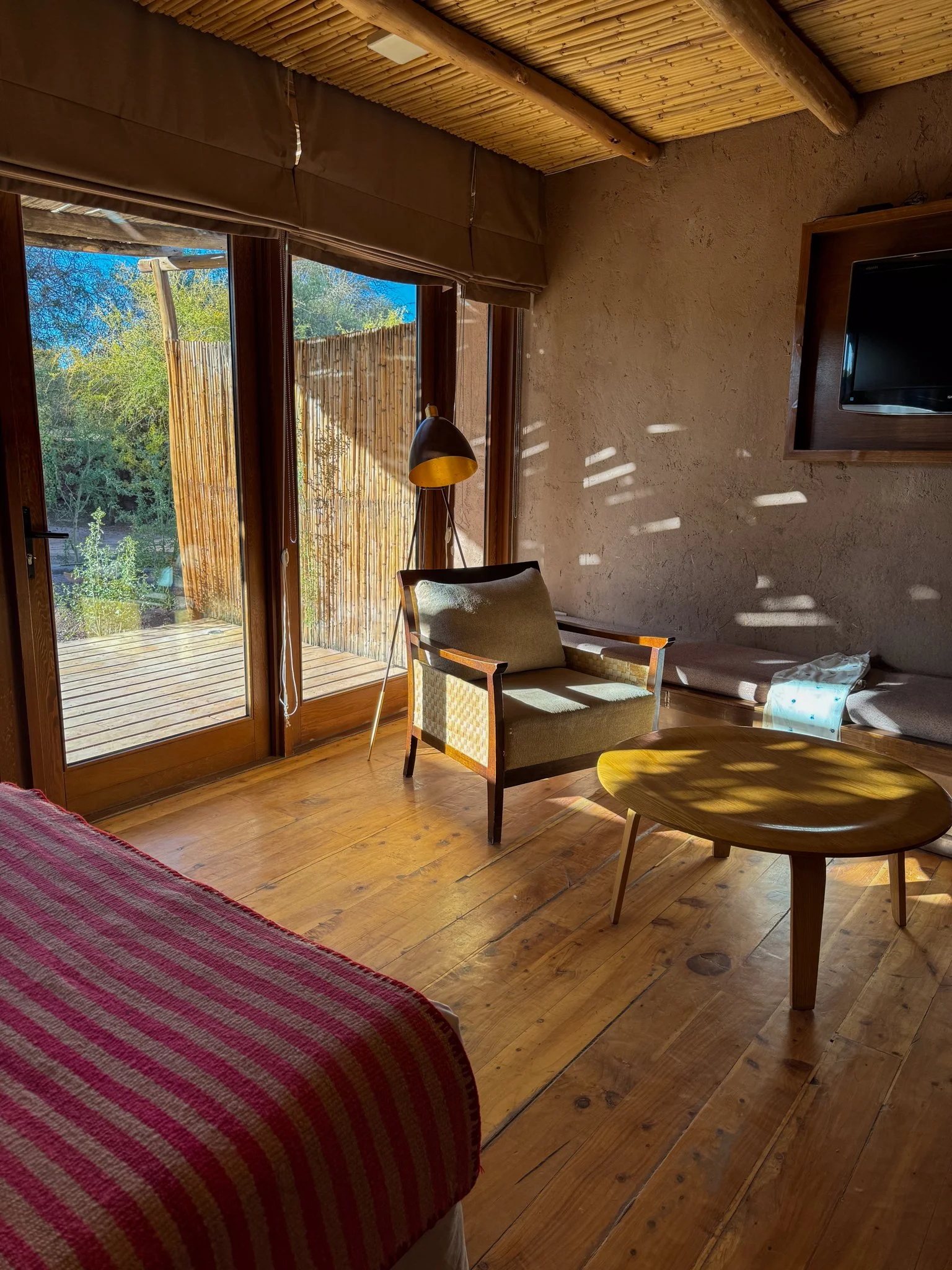 Desert-inspired room at Cumbres San Pedro de Atacama with wood floors, a private patio, and natural light