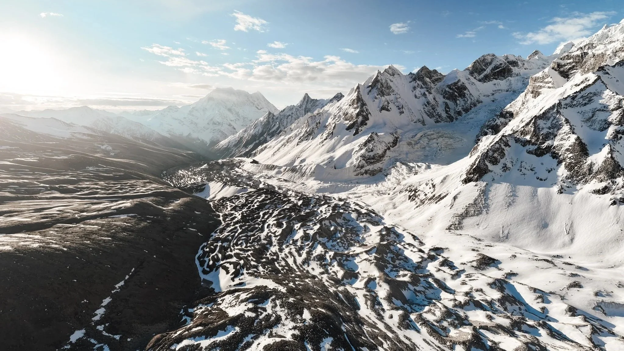 Drone aerial view of Himalayan dome peak and glacier near Larkya La Pass on the Manaslu Circuit Trek, deep blue sky overhead