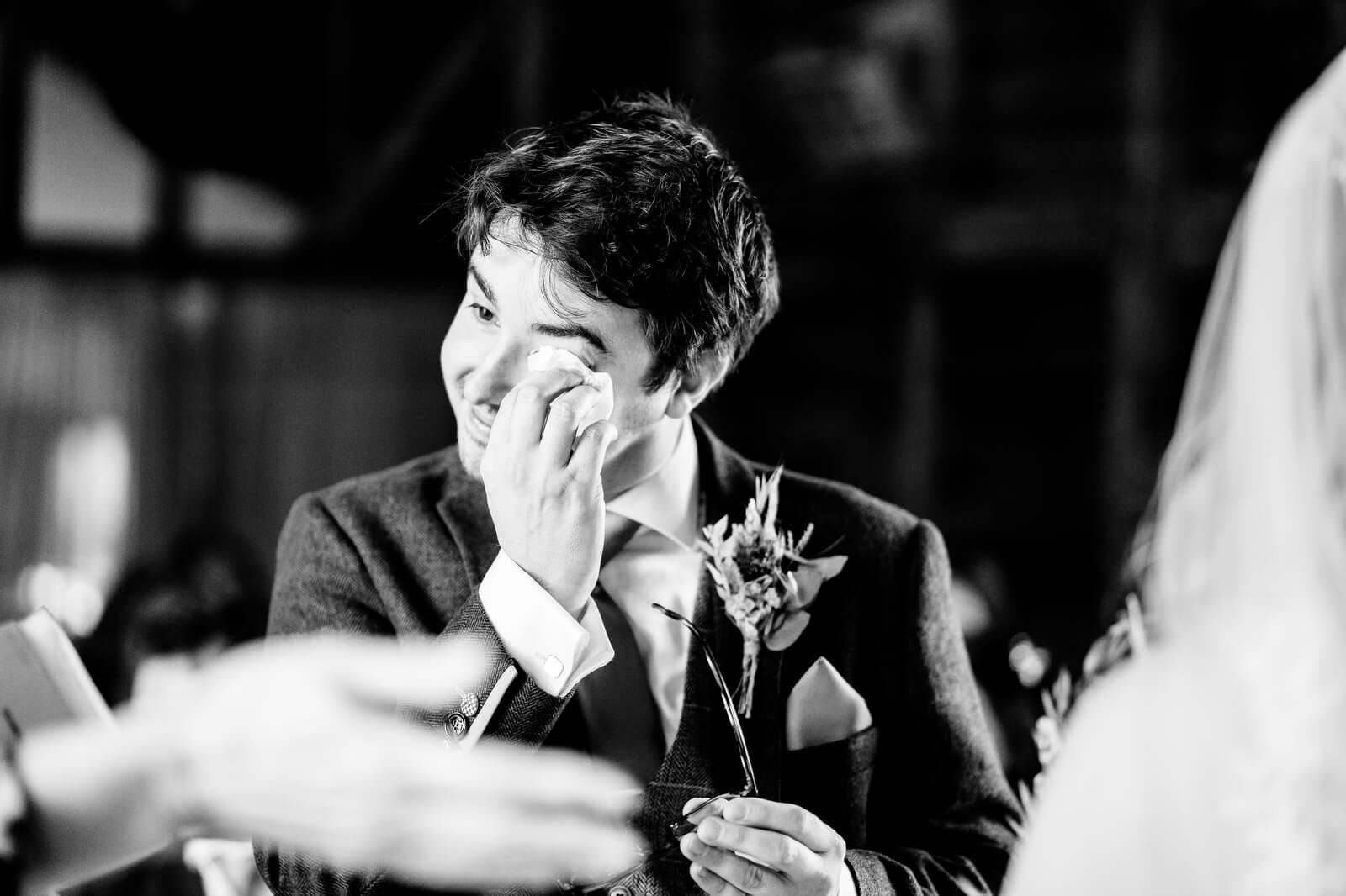 groom sheds a tear during ceremony silchester farm in black and white