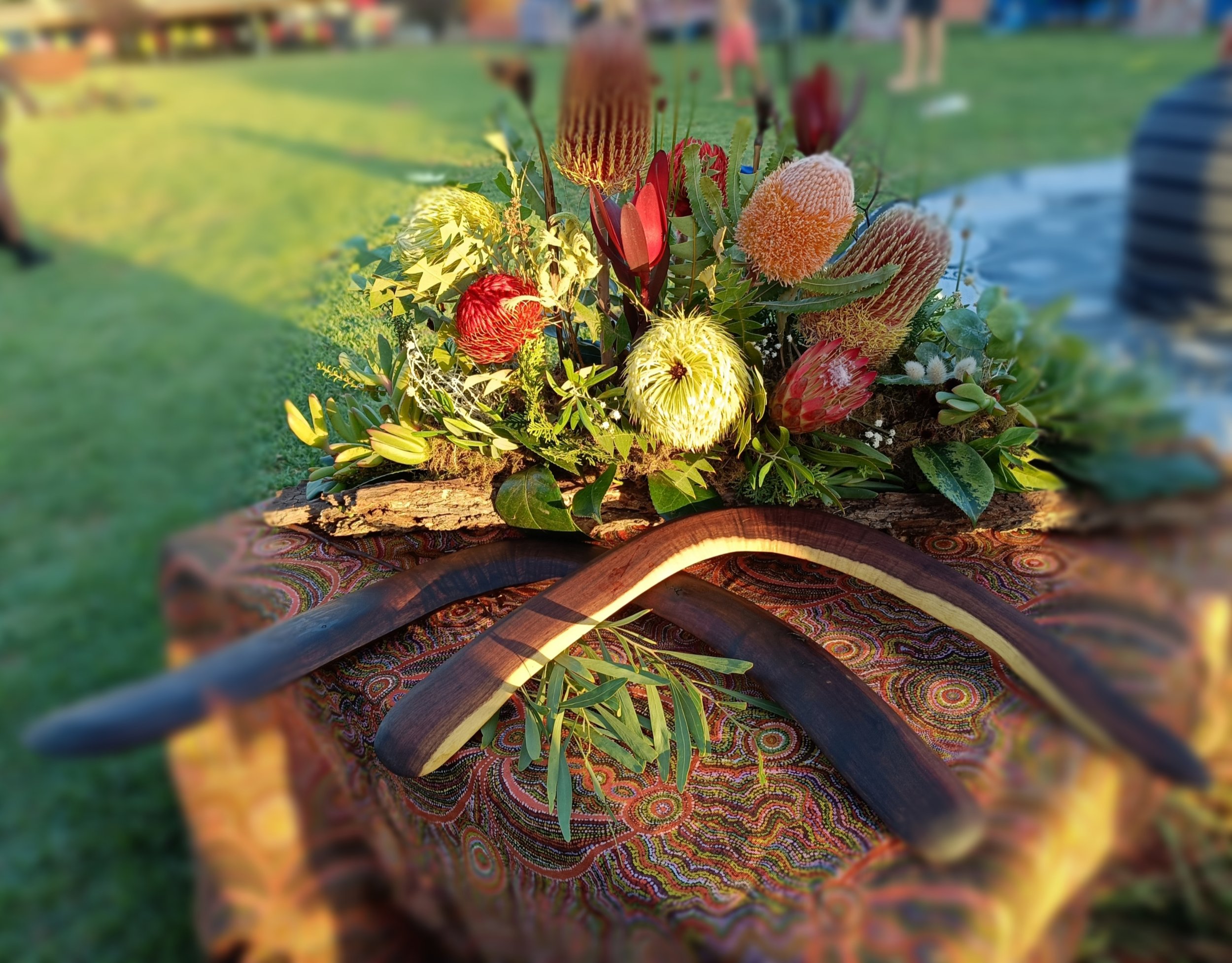 Mixed native floral with Ngarrindjeri bushtucker. Boomerangs made by Otis Elroy.