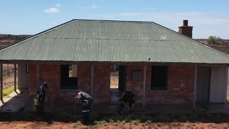  Community members working on one of the cottages. 