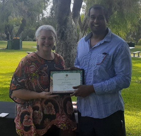  Steph presents volunteer Dulith with a certificate recognising his skilled volunteer support to communities. 