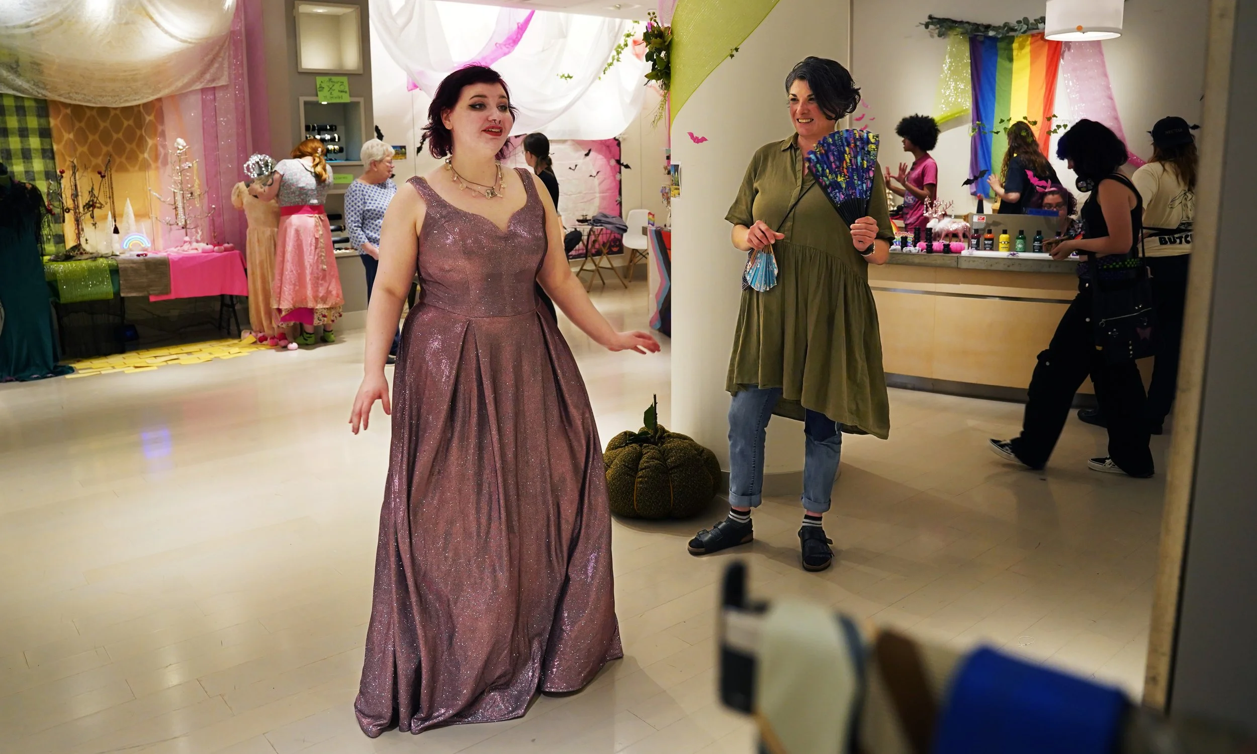  Ash LeBlanc, left, checks the fit of a prom dress in a mirror while Beth Dryer watches April 29, 2025 in Norfolk. The Creative ReUse Center hosted an alteration event to help teens get ready for Rainbow Prom, a dance for LGBTQ students. 