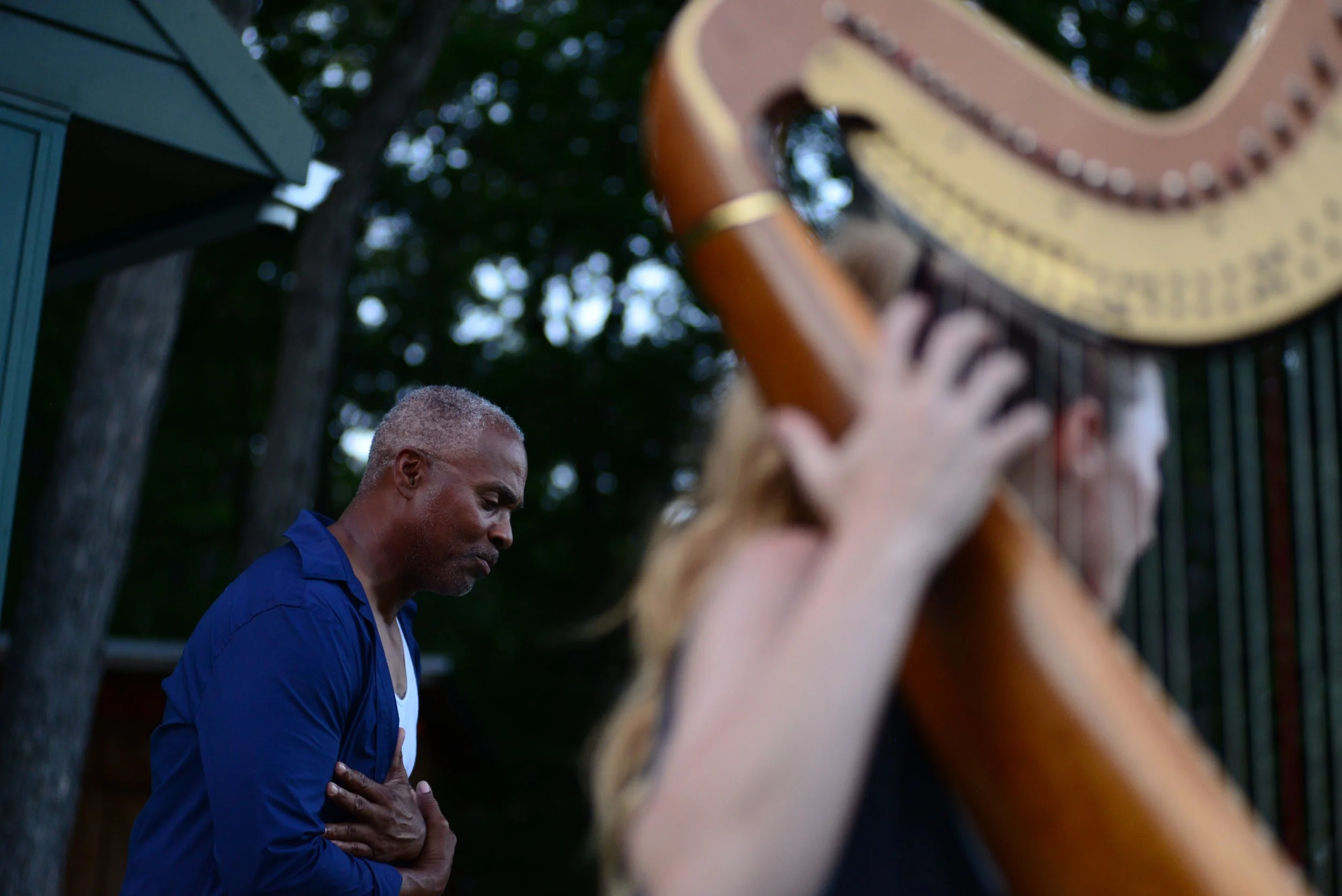  Richard E. Harris, Jr., left, sings a verse from “Twelfth Night,” accompanied by Ruth Acuff on harp August 23, 2021 in Columbia, Missouri. Harris’s voice filled the outdoor performance space, a natural acoustic shell formed by a lake and dense tree 