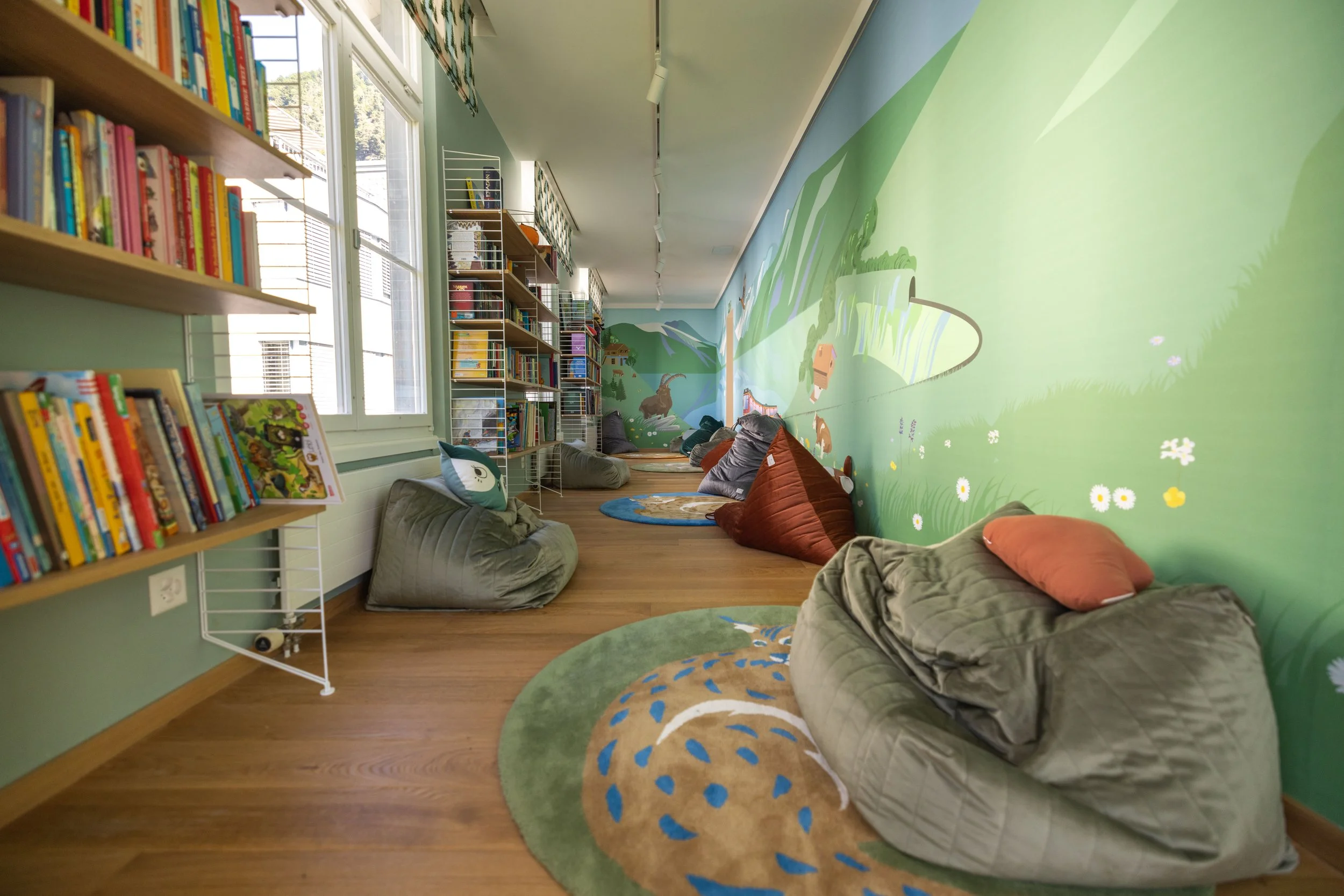 Zona giochi e spazio esperienziale dedicato ai bambini nell’area famiglia del Victoria-Jungfrau Interlaken, con arredi su misura e materiali naturali