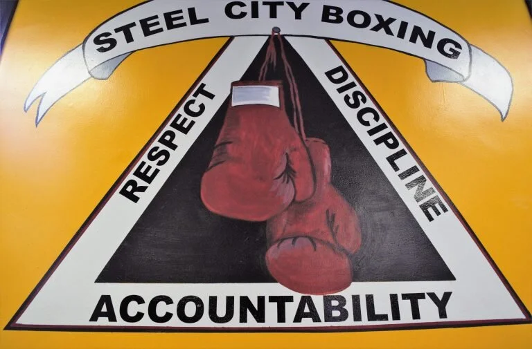 Steel City Boxing gym’s motto is painted on the wall. Photo by Neil Strebig.