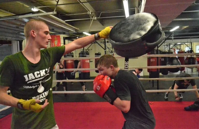 Josh Mook coaching Brody White through a boxing drill. Photo by Ty Polk