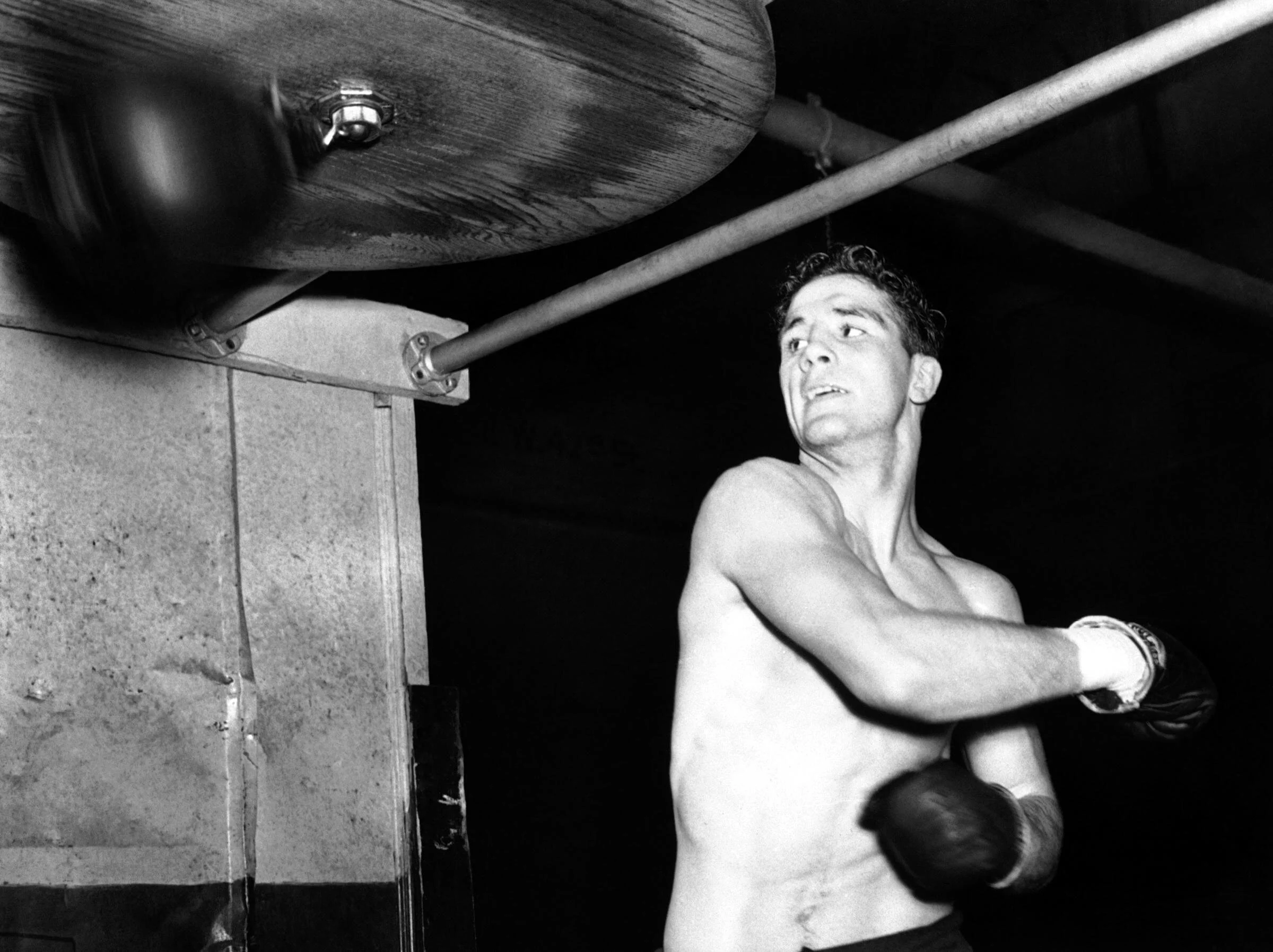 American Light-Heavyweight Billy Conn, of Pittsburgh, takes a whack at the punching bag in New York on Feb. 7, 1939, as he prepared for a fight against Fred Apostoli, in Manhattan February 10. ASSOCIATED PRESS