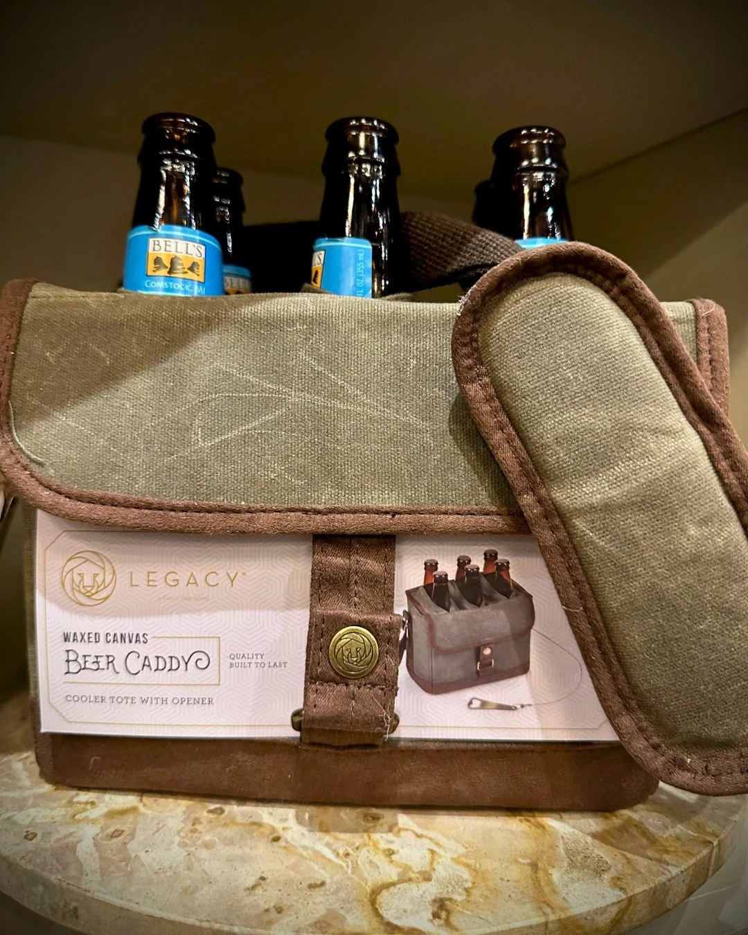 Tailgate season is in full swing! 🍻 This waxed canvas beer caddy from Legacy keeps your brews cold and your hands free &mdash; complete with a built-in bottle opener. Find it at Metamora General.