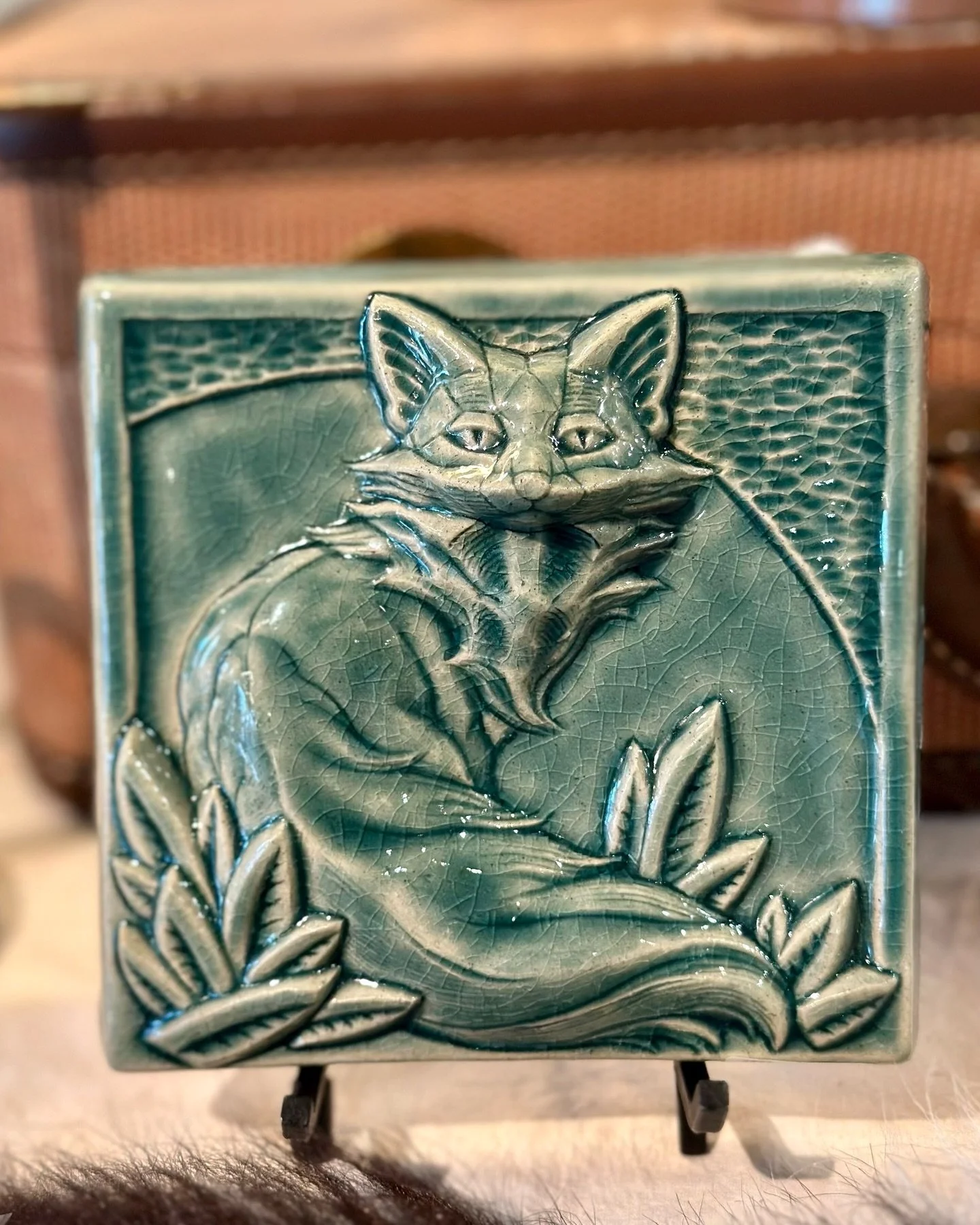 Handcrafted by Pewabic Pottery in Detroit, this relief tile features a fox surrounded by botanical details, finished in a rich blue-green crackle glaze. A timeless Arts &amp; Crafts&ndash;inspired piece that looks just as good on a shelf as it does s