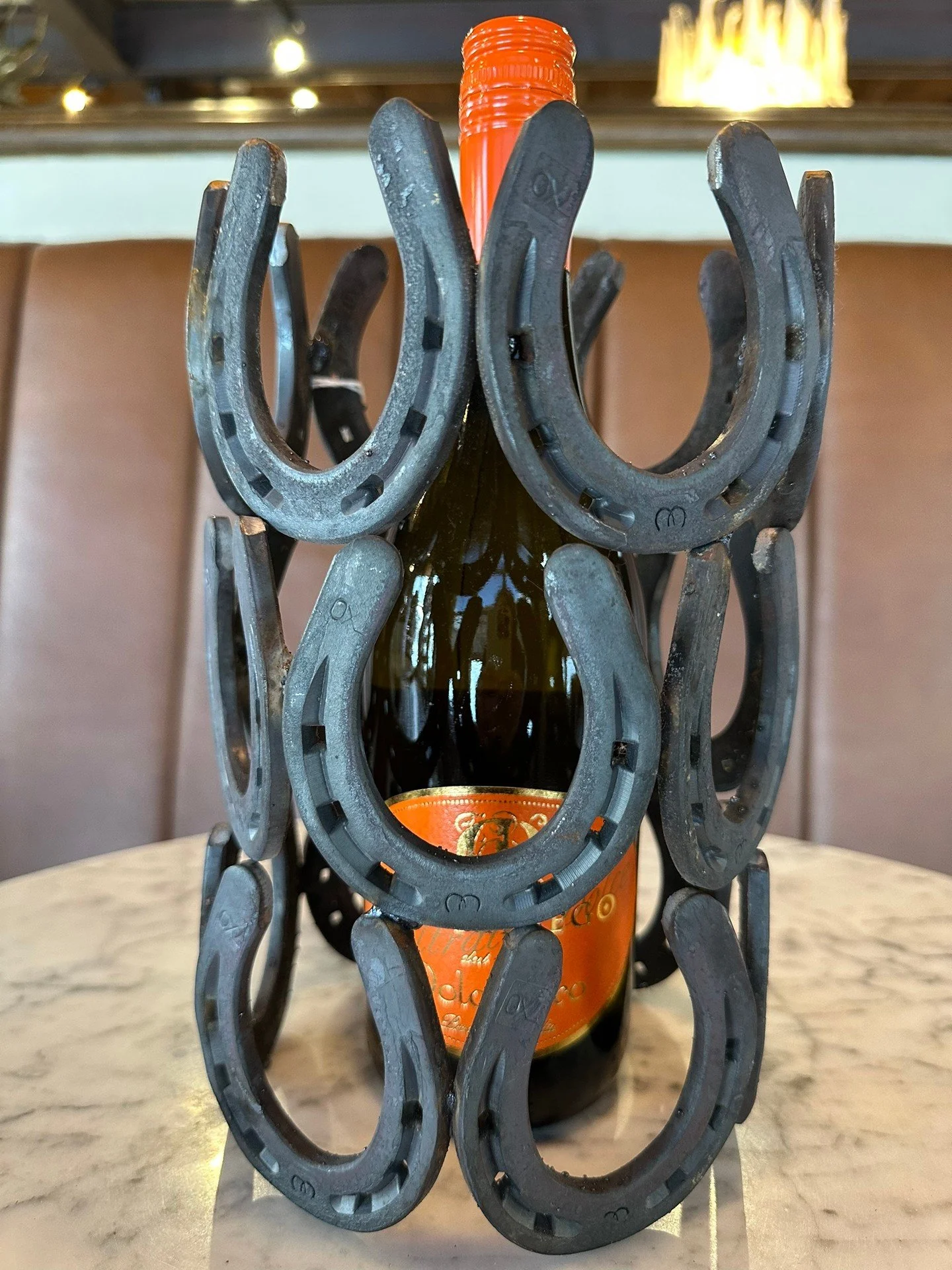 Handmade from reclaimed horseshoes, this versatile piece works beautifully as a wine holder, candle holder, or floral vase&mdash;functional, sculptural, and full of character.

Perfect for dining tables, mantels, or gifting to your favorite horse lov