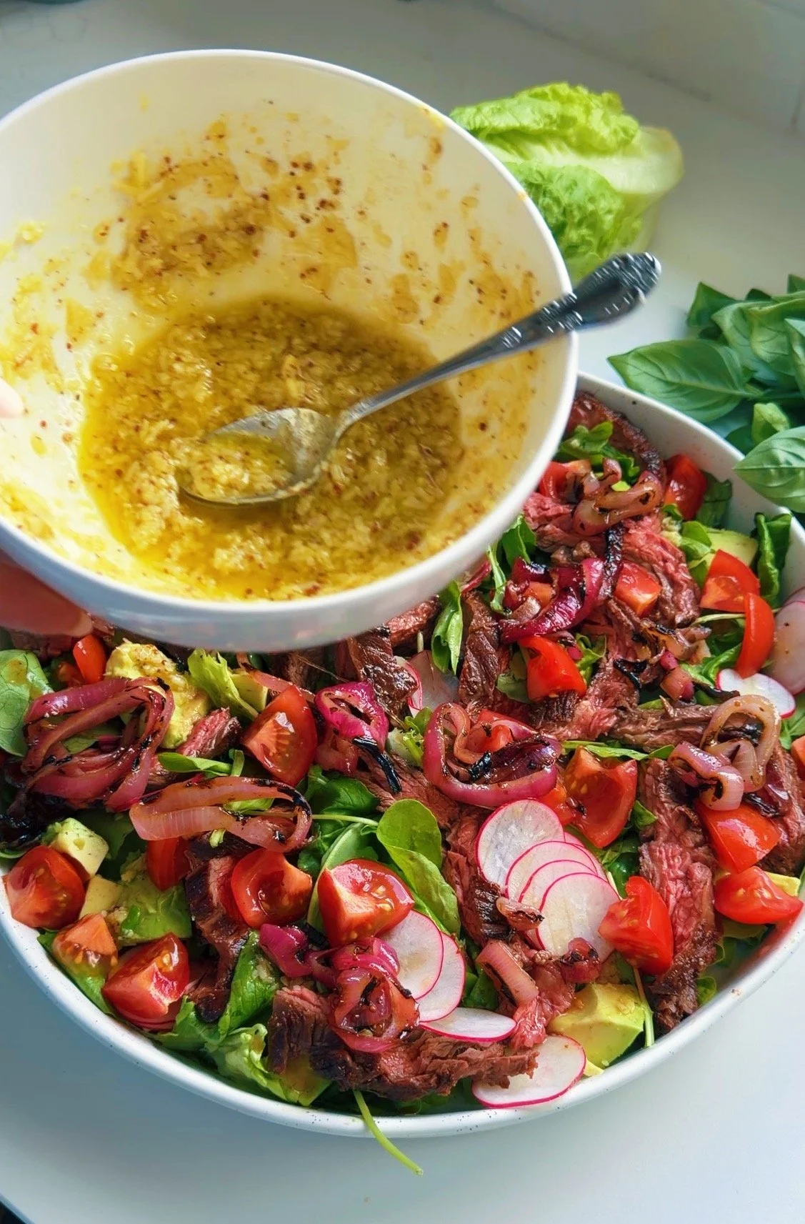Parmesan black pepper dressing drizzled over a BBQ steak salad.