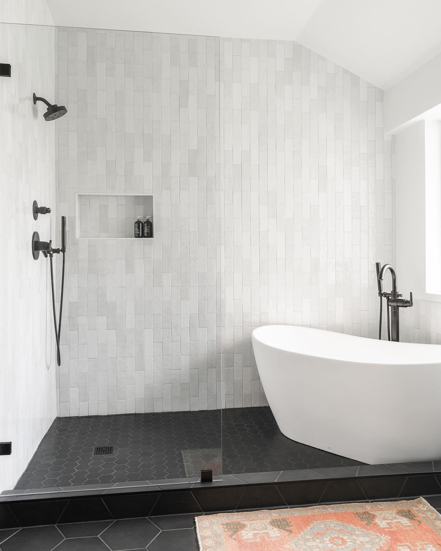 Hello transformation! ✨ 
.
From beige walls, carpet and a chrome framed shower to a bright, complete wet area with a freestanding tub that pops against the continuous black hex floor, and those gorgeous floor-to-ceiling zellige tiles that draw your e