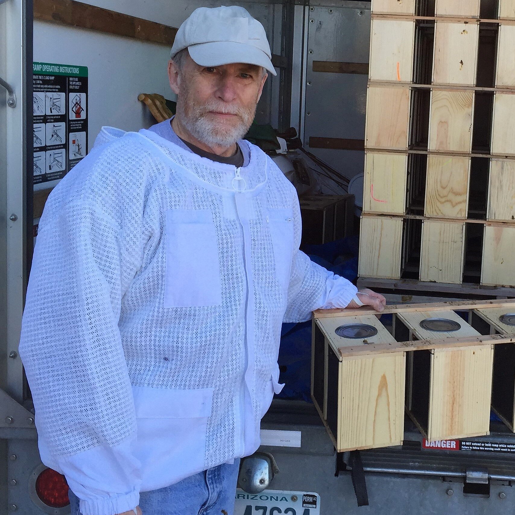 A Bee Shed team member with many boxes of packaged bees for sale to beekeepers