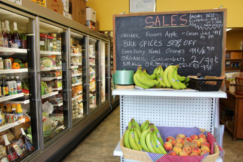 A line of full coolers and a chalkboard displaying sale items