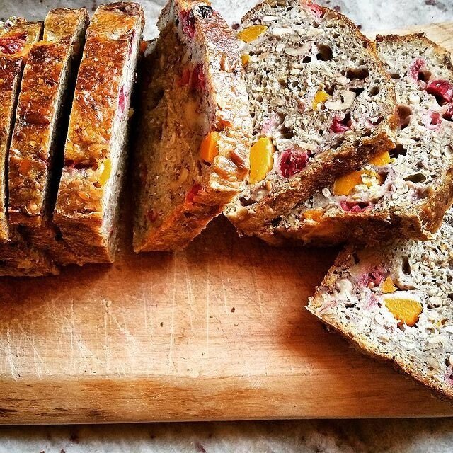 Sliced bread with chunks of bright red and yellowfruit baked in