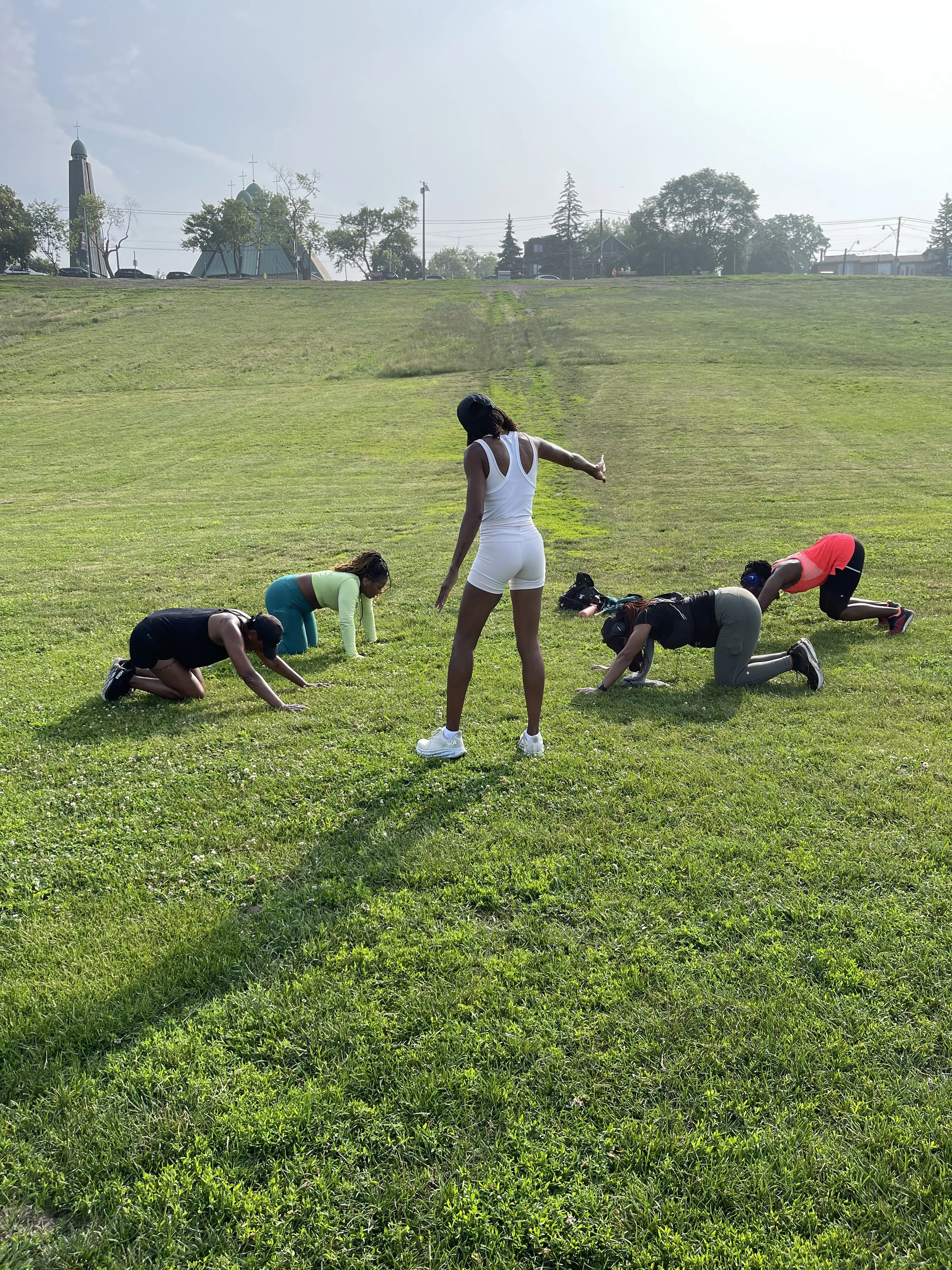 	
Hill Run Club Training group exercising outdoors on a grassy hill, with one woman leading and four women