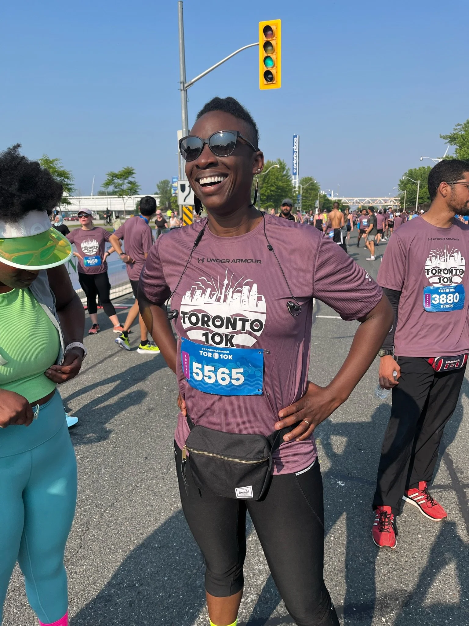A Black woman smiling and posing during the Toronto 10K race.