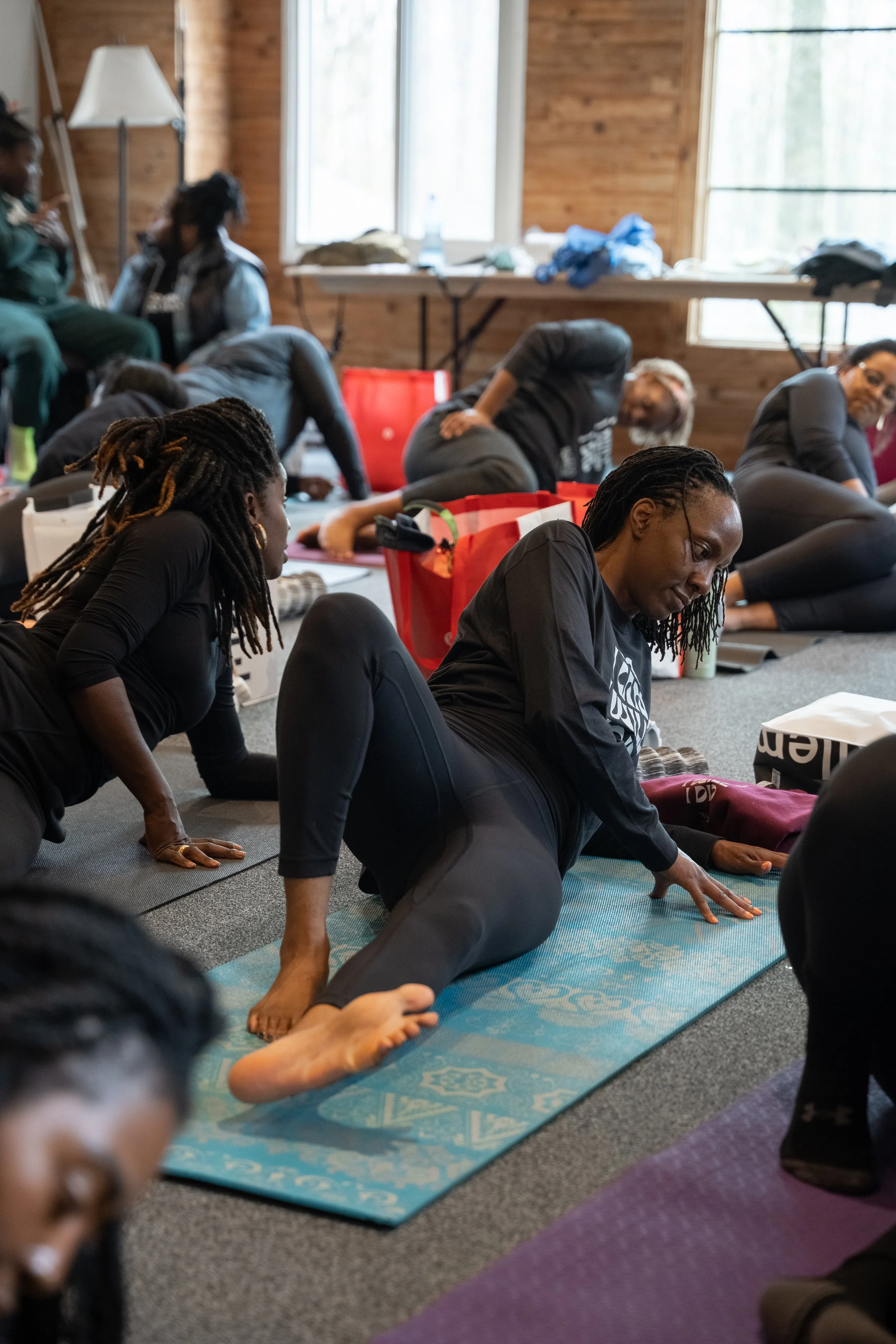 People participating in a yoga or stretching class indoors on exercise mats.