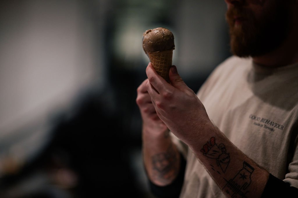 Person holding an ice cream cone with chocolate ice cream.
