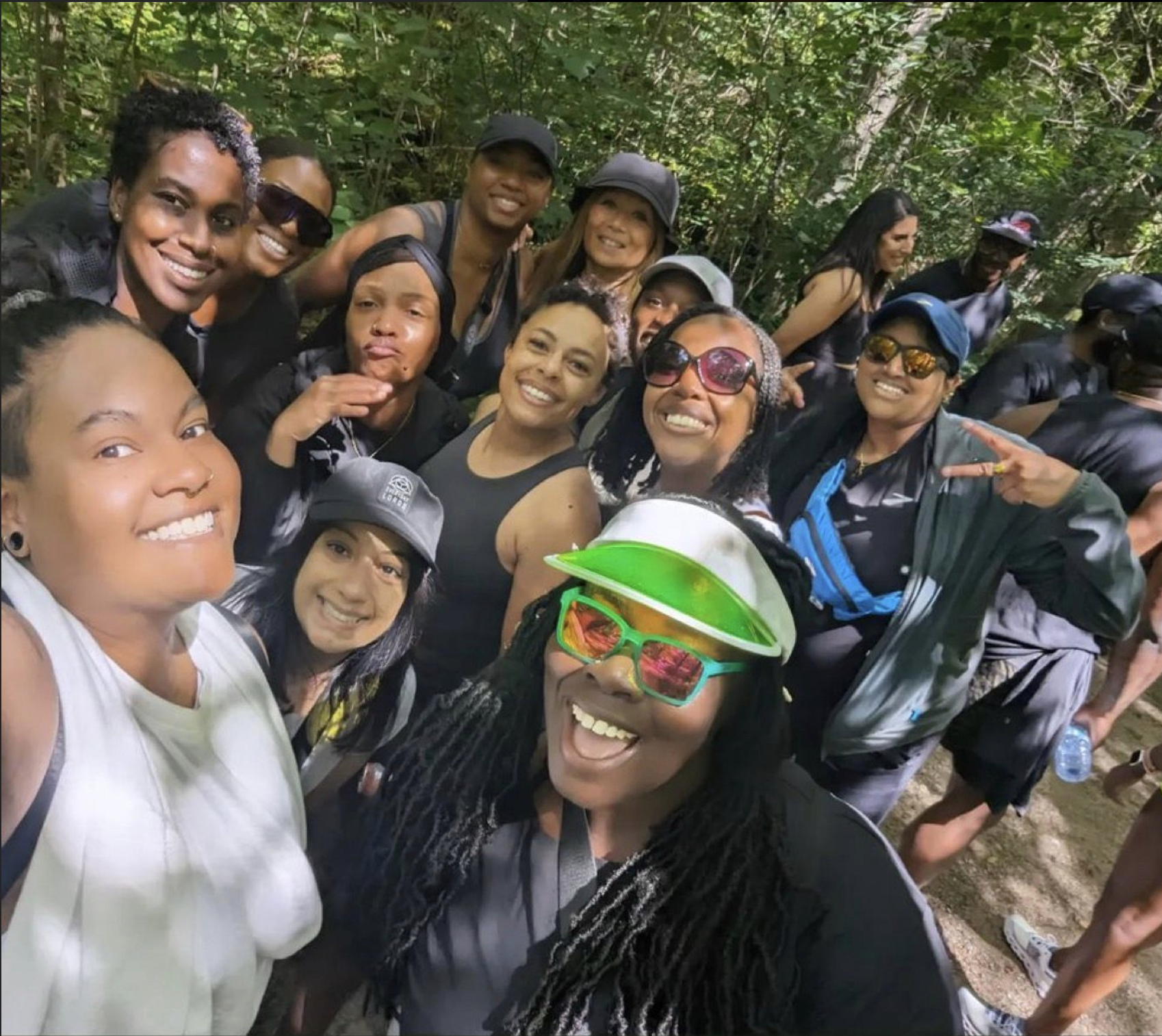 Hill run club members and a Fewer Roads Events in the outdoors, taking a selfie and smiling.