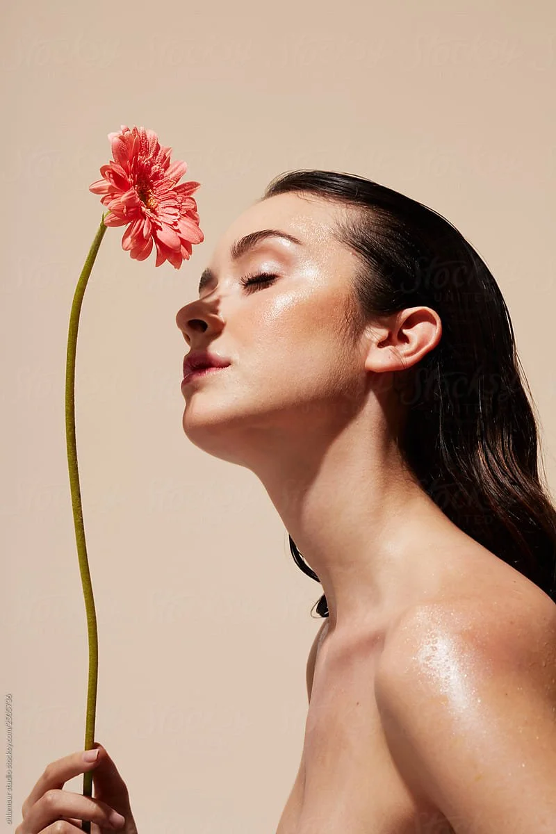 woman with flower and dewy skin