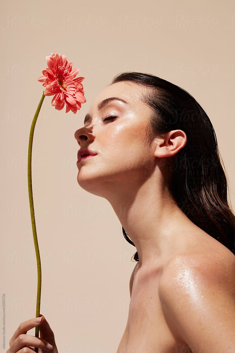 woman with flower and dewy skin