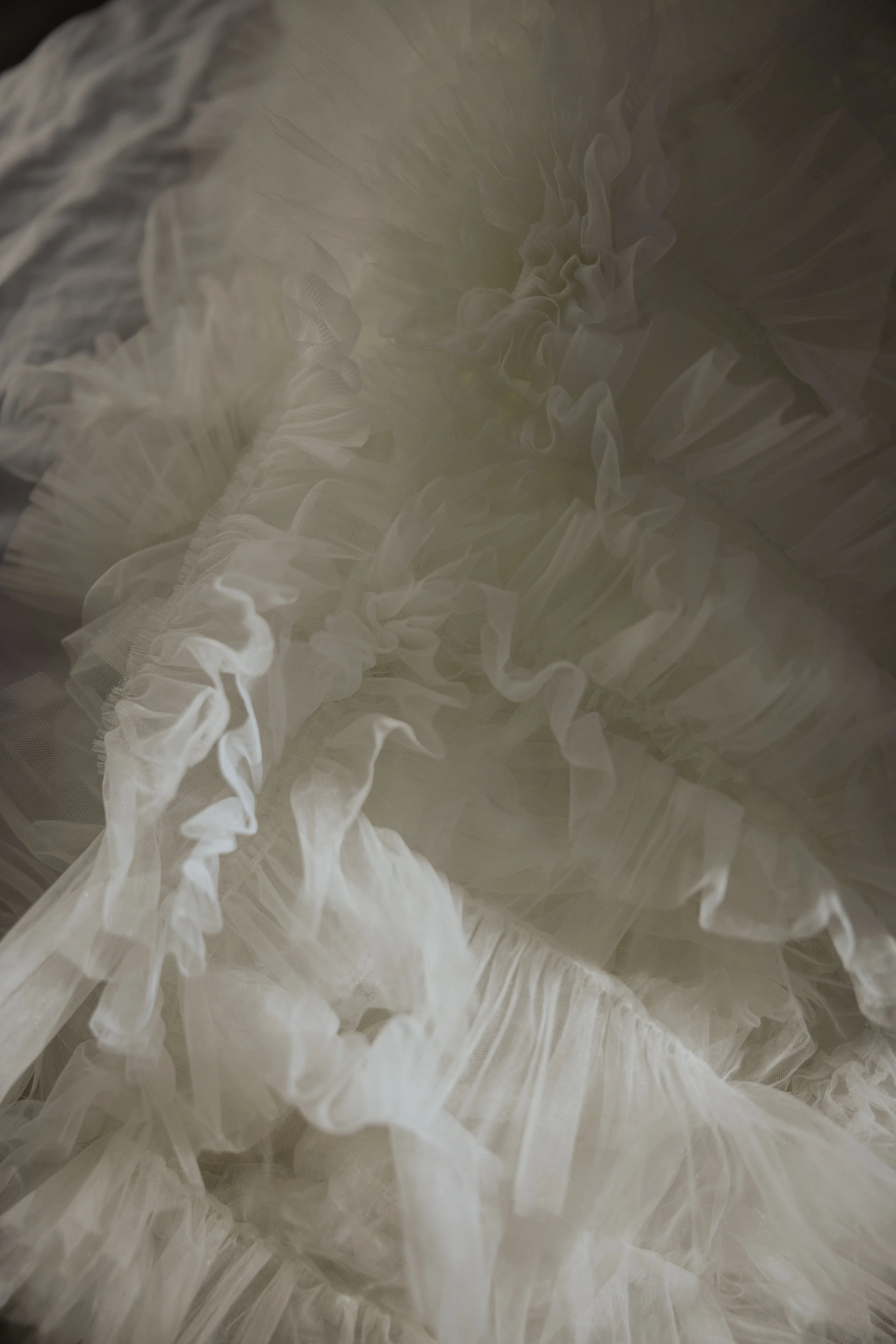 Close-up of white ruffled fabric with layers and sheer textures.