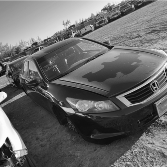 Honda accord at a card yard with no tires on it.