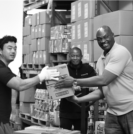 Three man helping in a food bank warehouse.