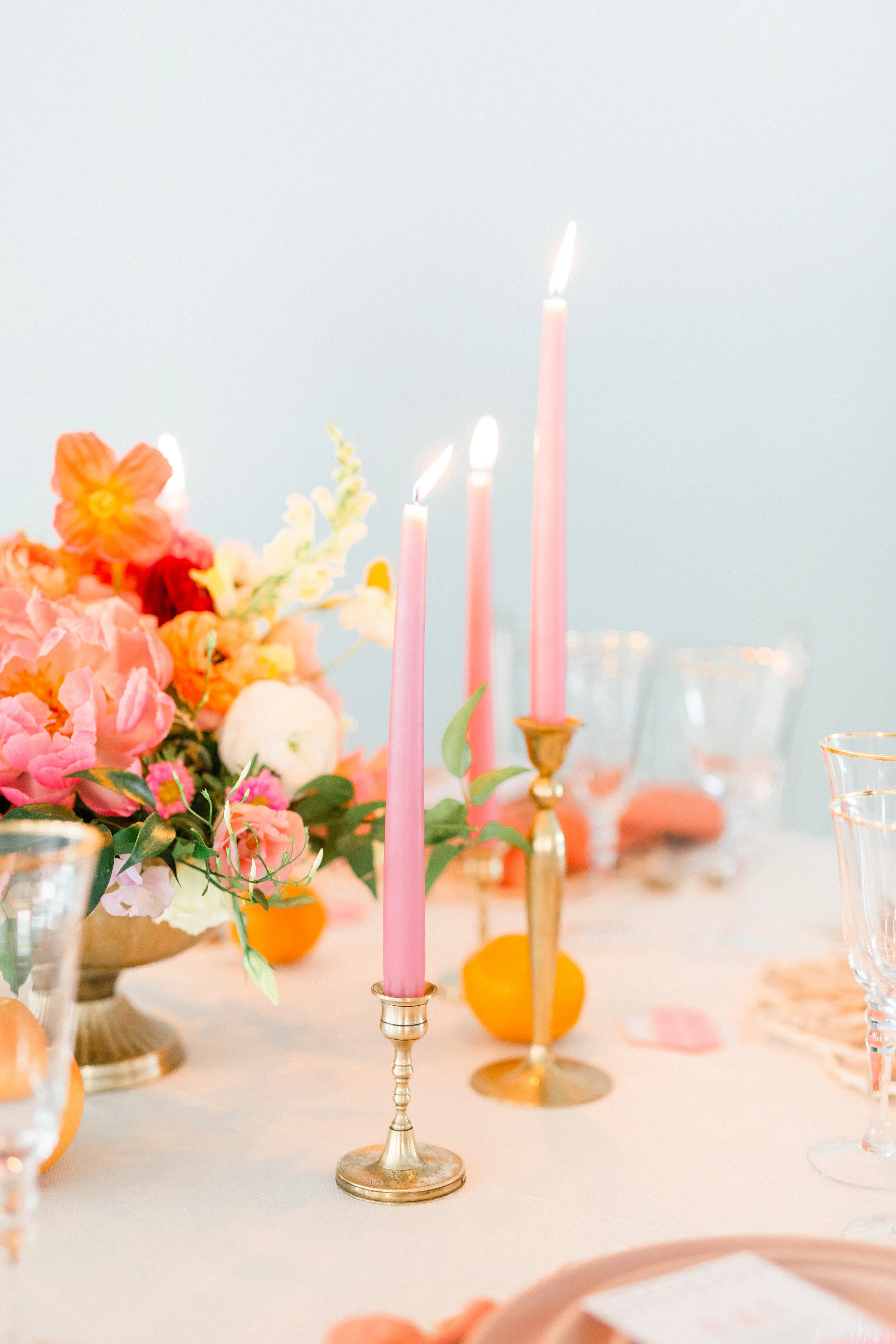 Pink lit candles on a pale pink tablecloth with flowers and glassware I Palm Springs Soiree Styled Shoot I Wedding Planning by CK & Co Events