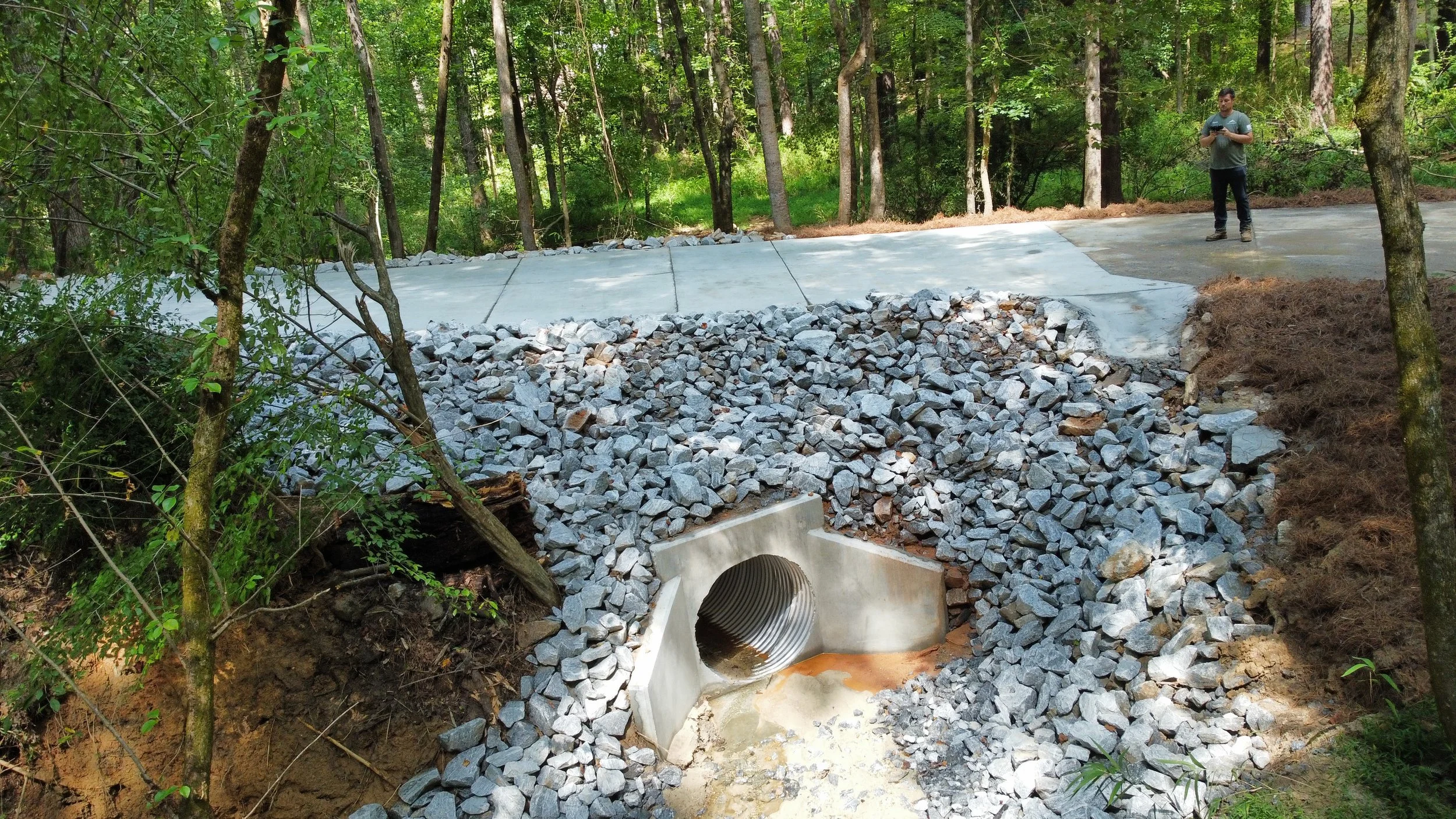 Metal culvert with concrete wingwall and pavement