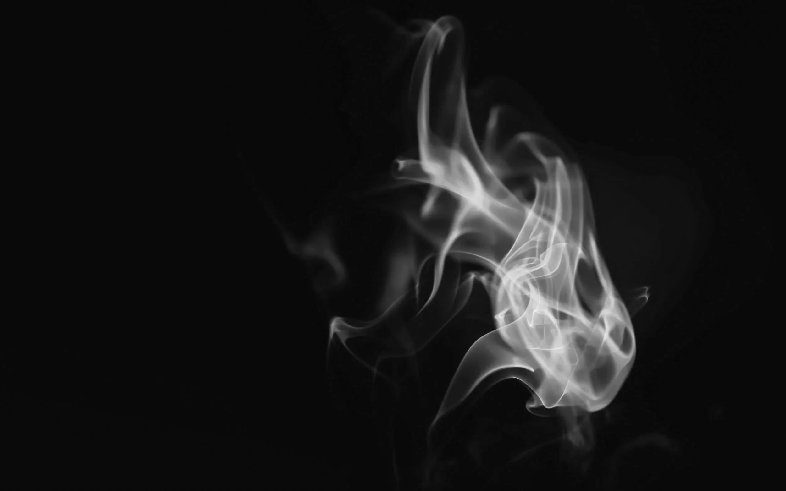 White smoke wisps swirling against a black background.