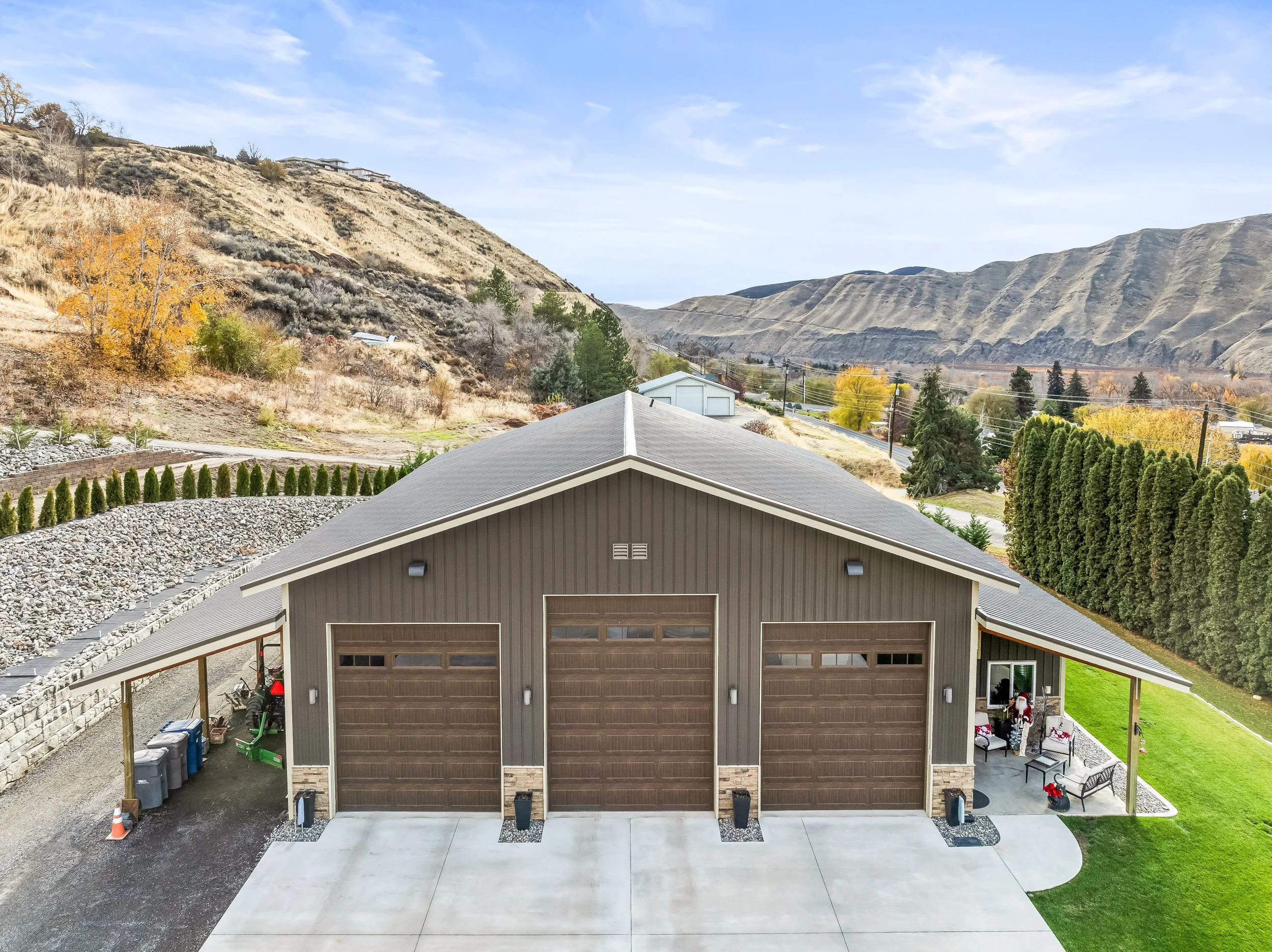 Alt text: "Aerial view of custom post-frame barn with metal roofing and large equipment doors in North Central Washington countryside"