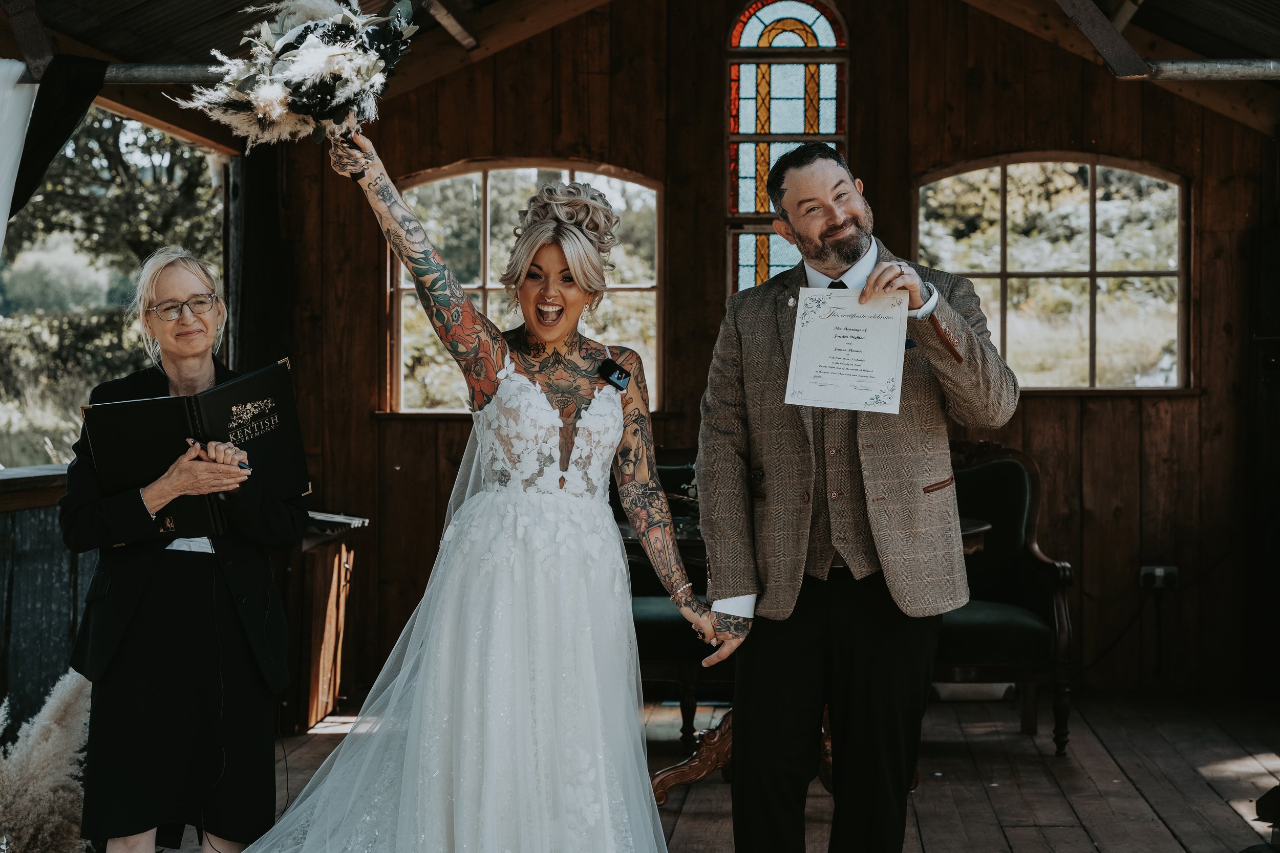 Tattooed couple celebrating getting married in wooden Love Shack Oak Tree Barn weddings Tonbridge
