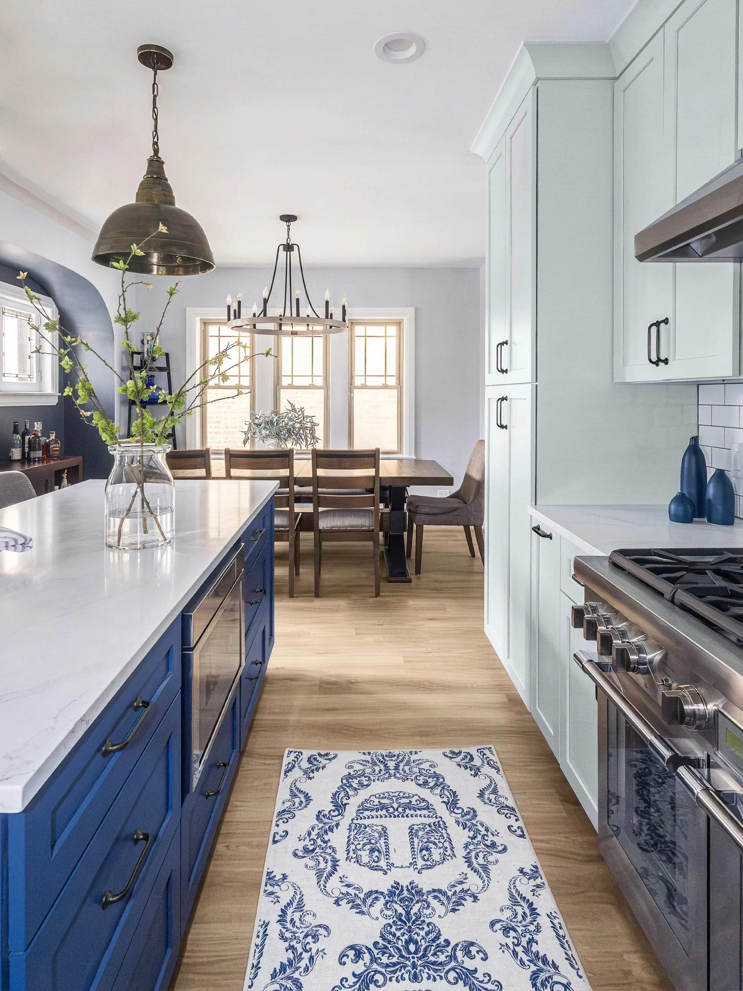An open-concept kitchen designed around a large central island and statement pendant lighting, creating a space that feels both functional and visually striking.

Design by @magdainteriors_ 
Remodel by @connstruct_llc 
Photos by @danet.photography 

