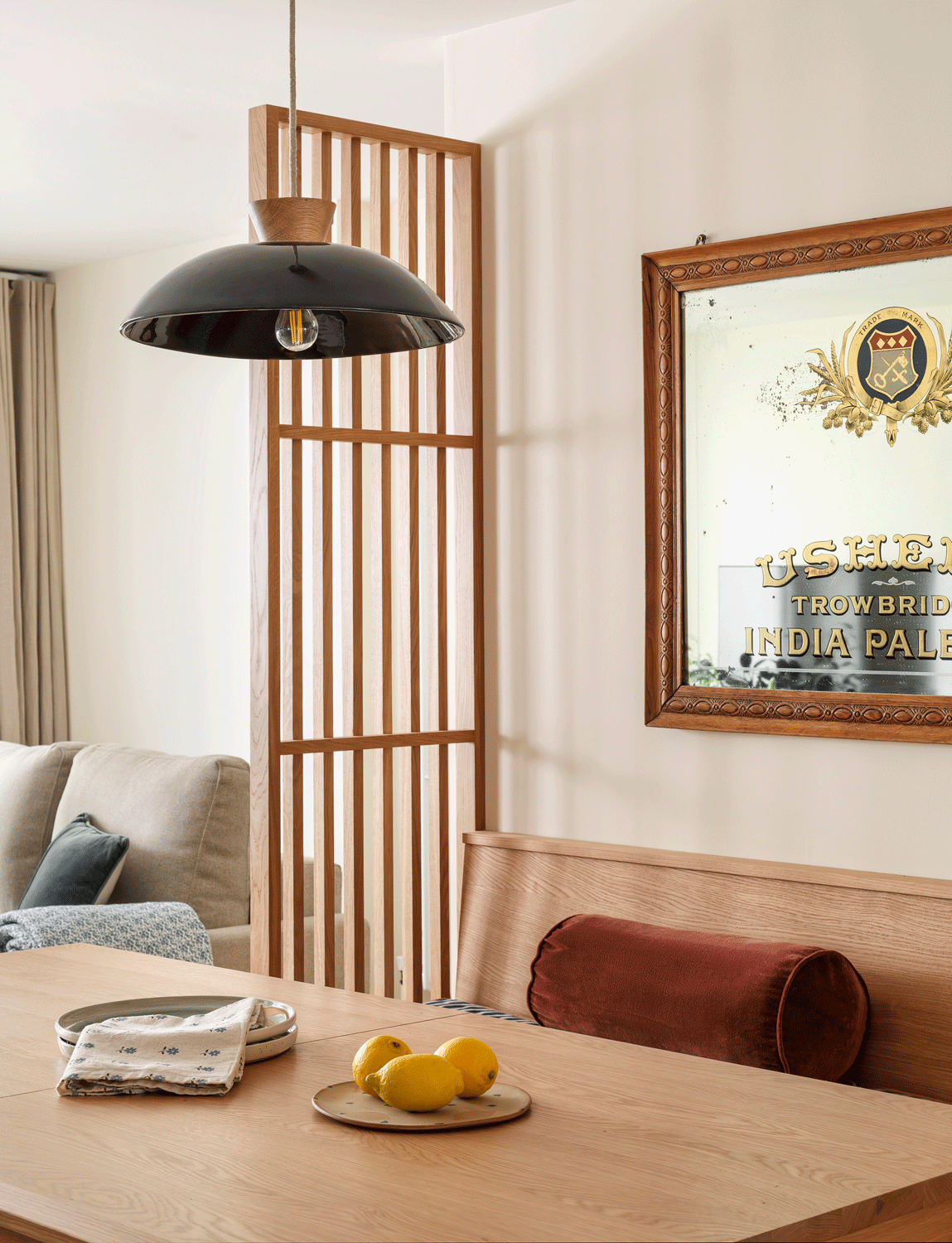 A slatted oak screen subtly divides the oak dining table and bench and the living space