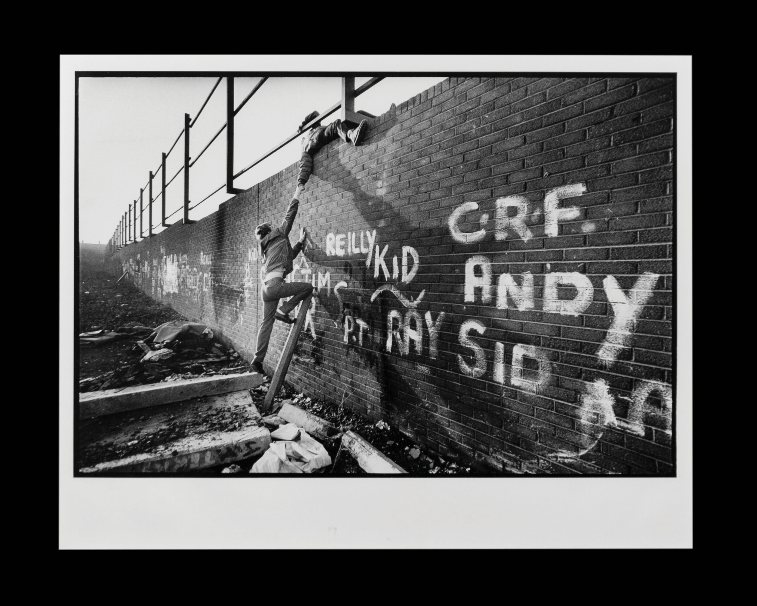  Local boys climb one of the largest Peace Walls scattered throughout Belfast to separate the Protestants and Catholics in Northern Ireland. 1988 