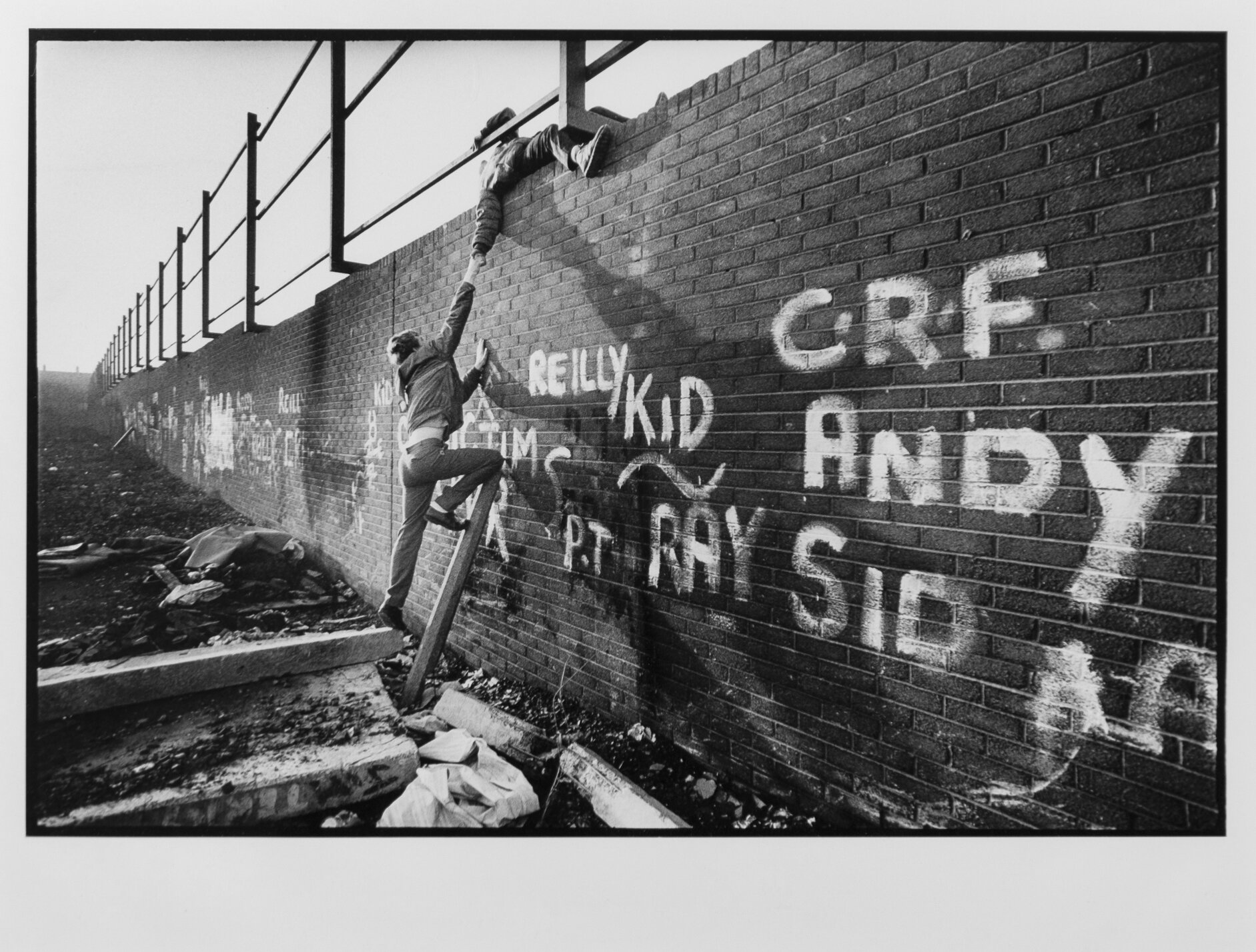  Local boys climb one of the largest Peace Walls scattered throughout Belfast to separate the Protestants and Catholics in Northern Ireland. 1988 